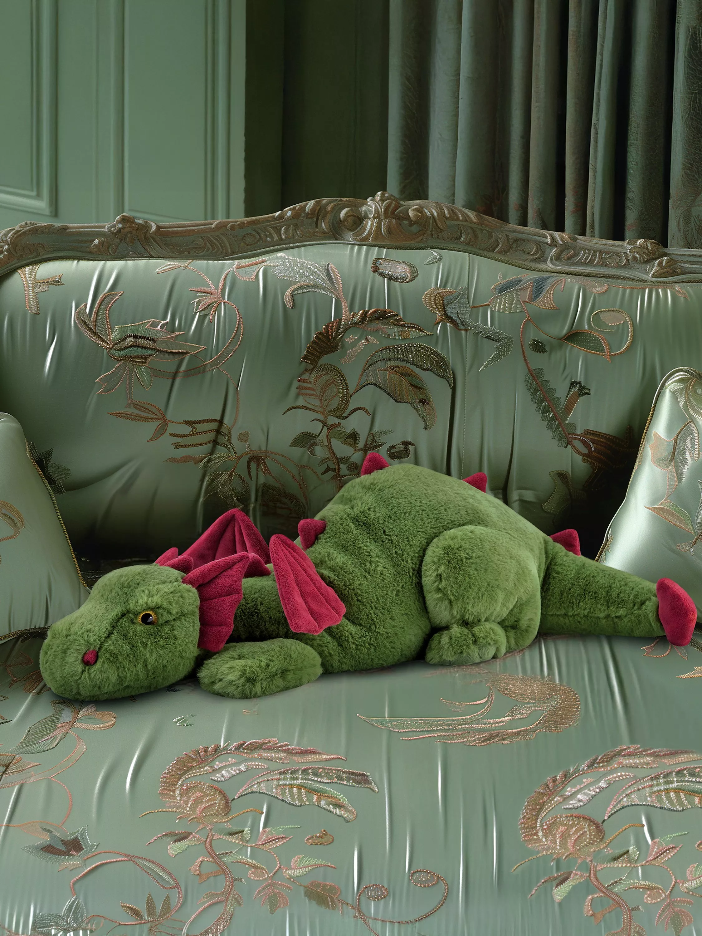 Green dragon soft toy on an ornate sage embroidered sofa in a vintage living room setting