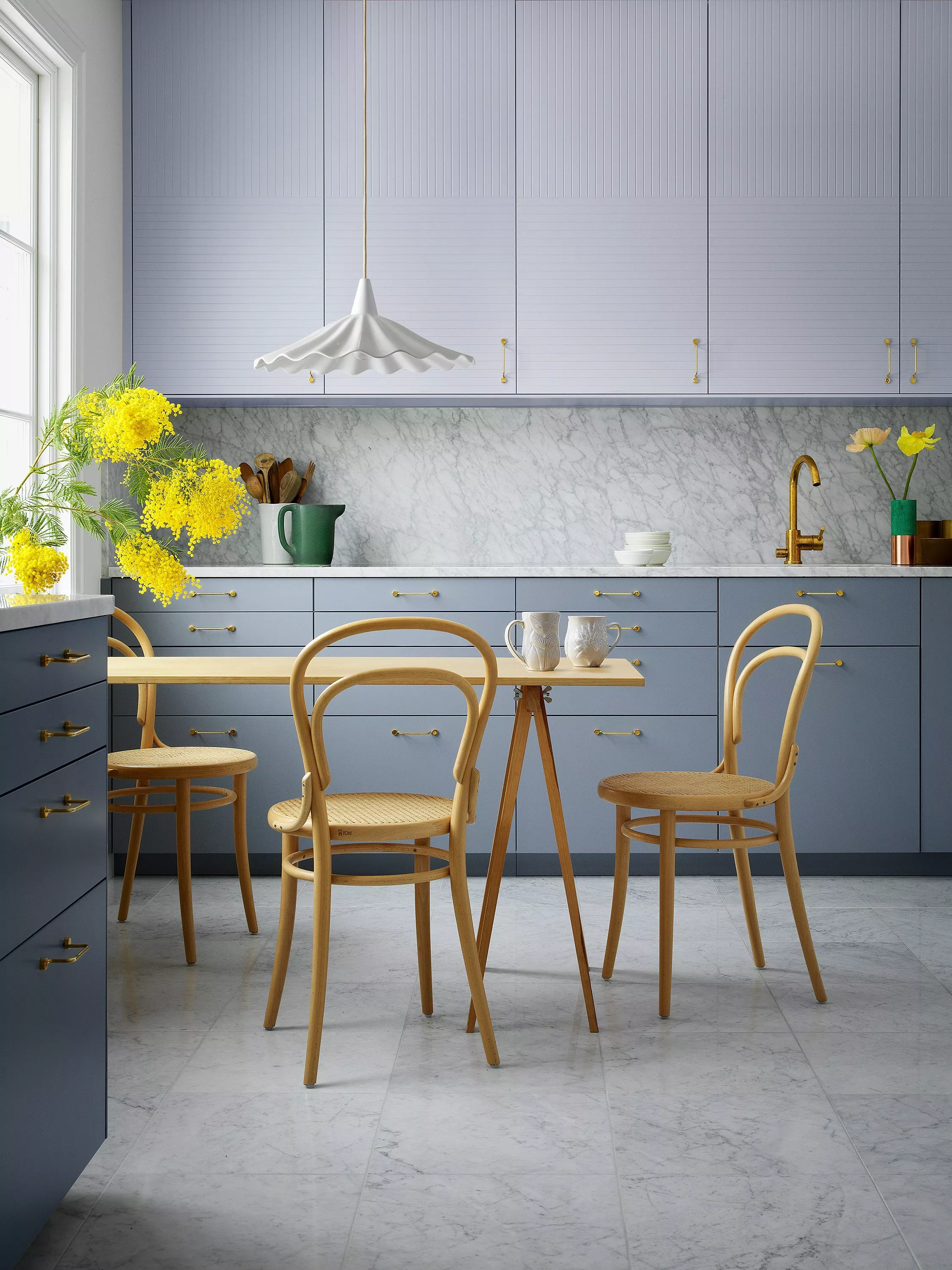 Ribbed glass pendant ceiling light hanging over dining table in modern kitchen, soft natural daylight indoors