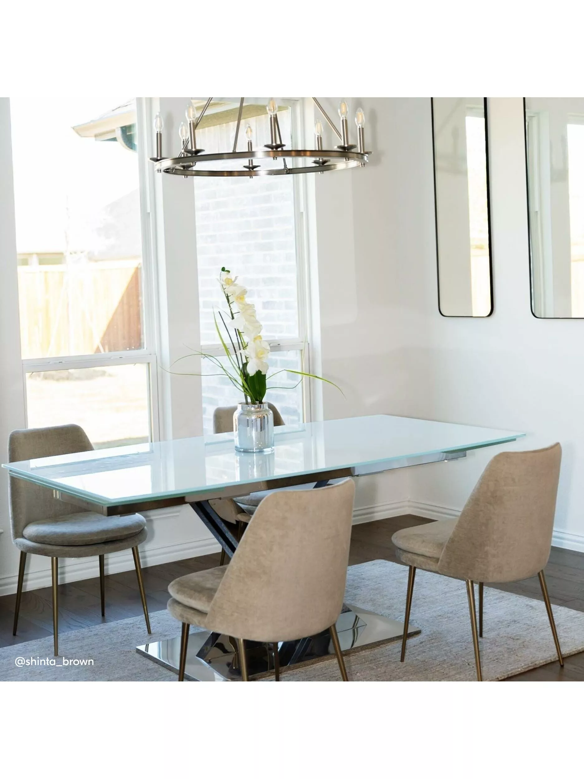 Dining room with a glass table and beige chairs with gold legs