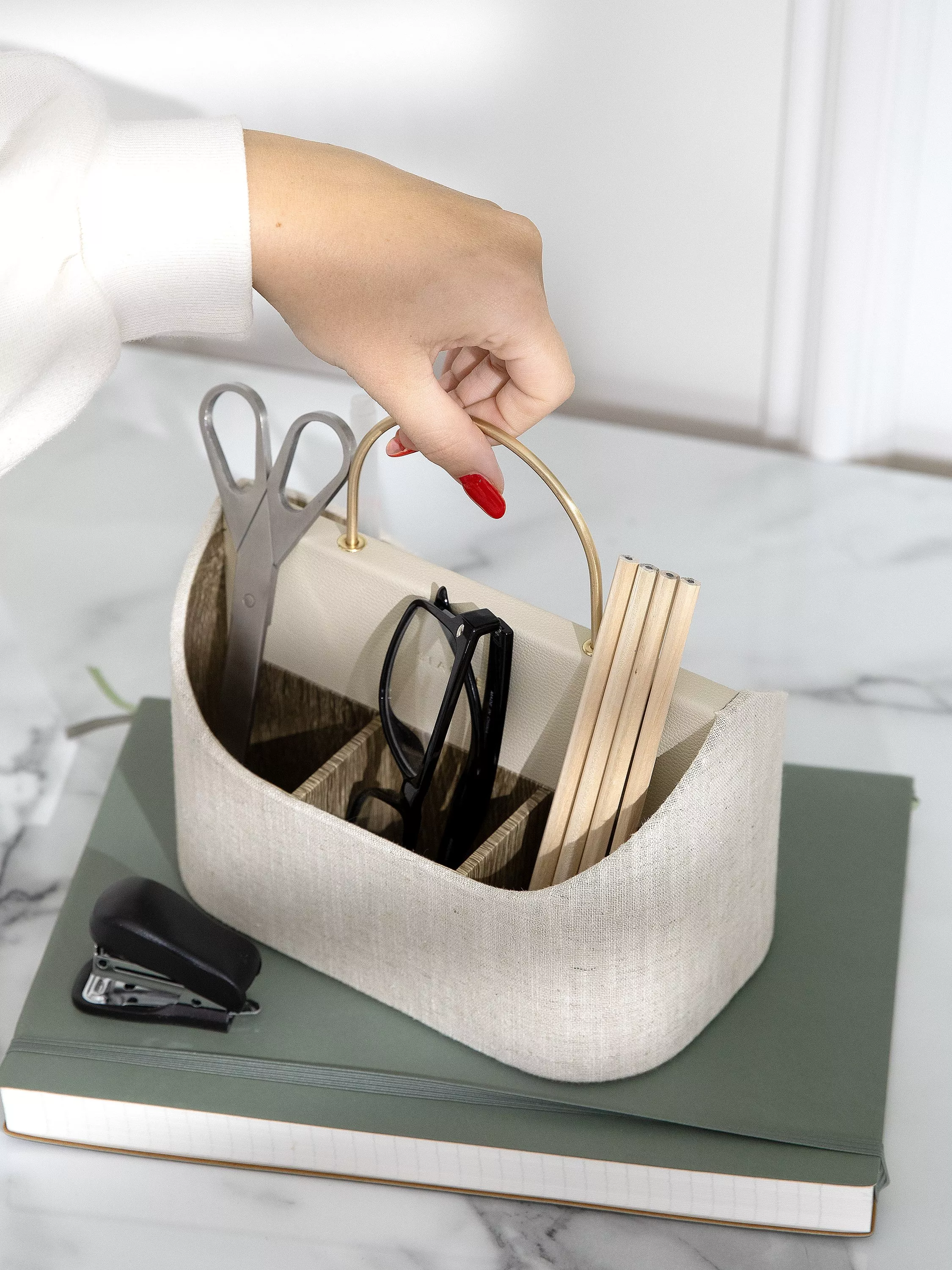 Minimalist home office desk organiser with laptop stand, tablet, stationery, notebook and glasses on marble table