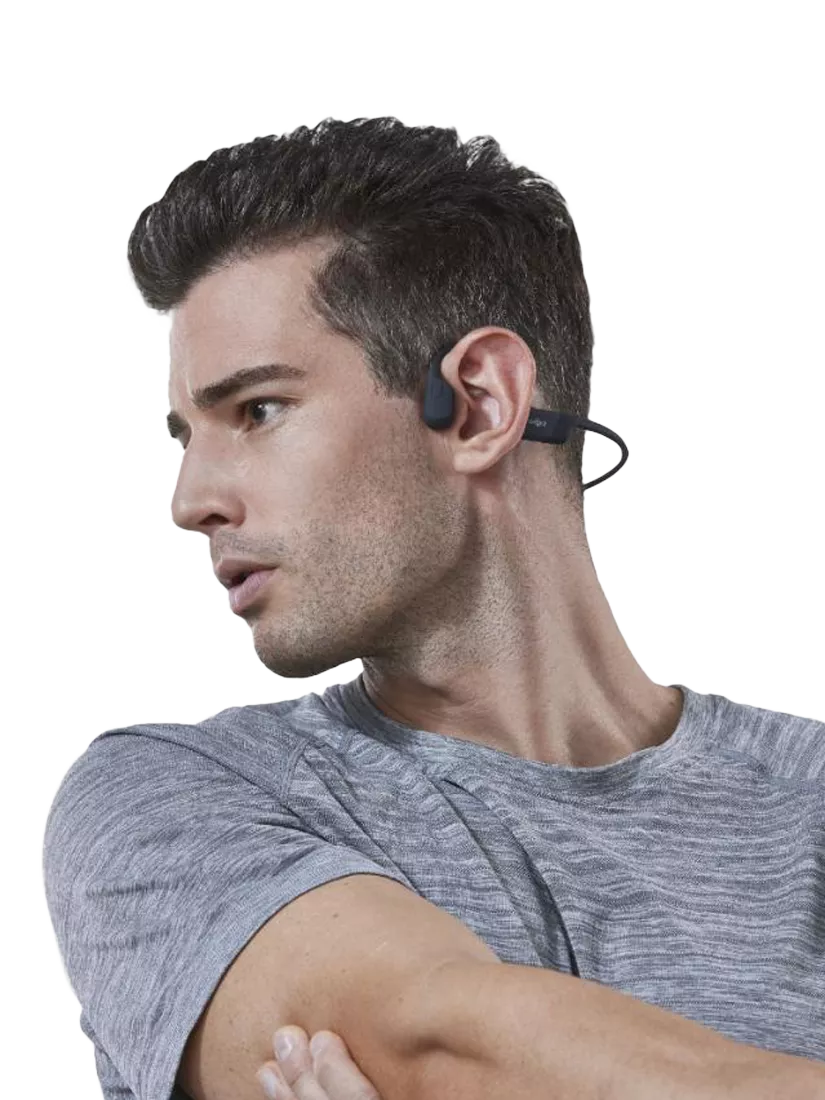 Man looking to the side in a sport-like pose wearing Open-ear headphones
