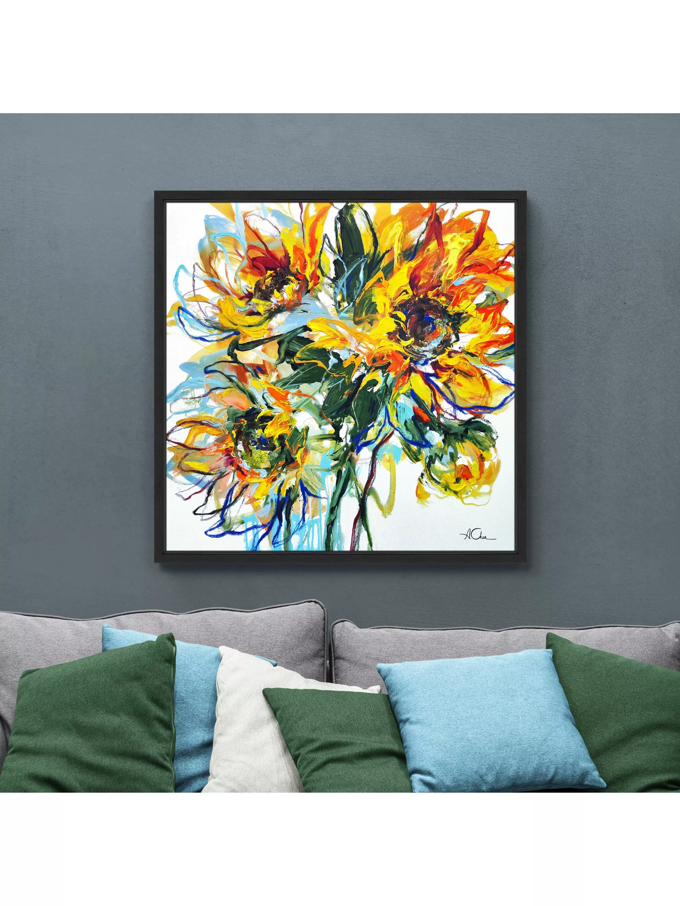 Framed abstract sunflower wall art print with bold yellow and orange brushstrokes above a modern sofa in living room
