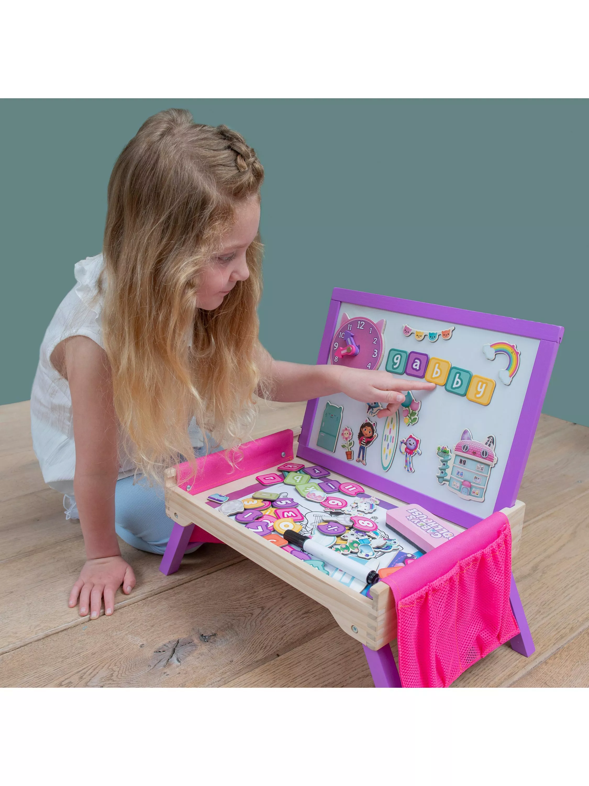 Girl playing with magnets and a wooden creation station