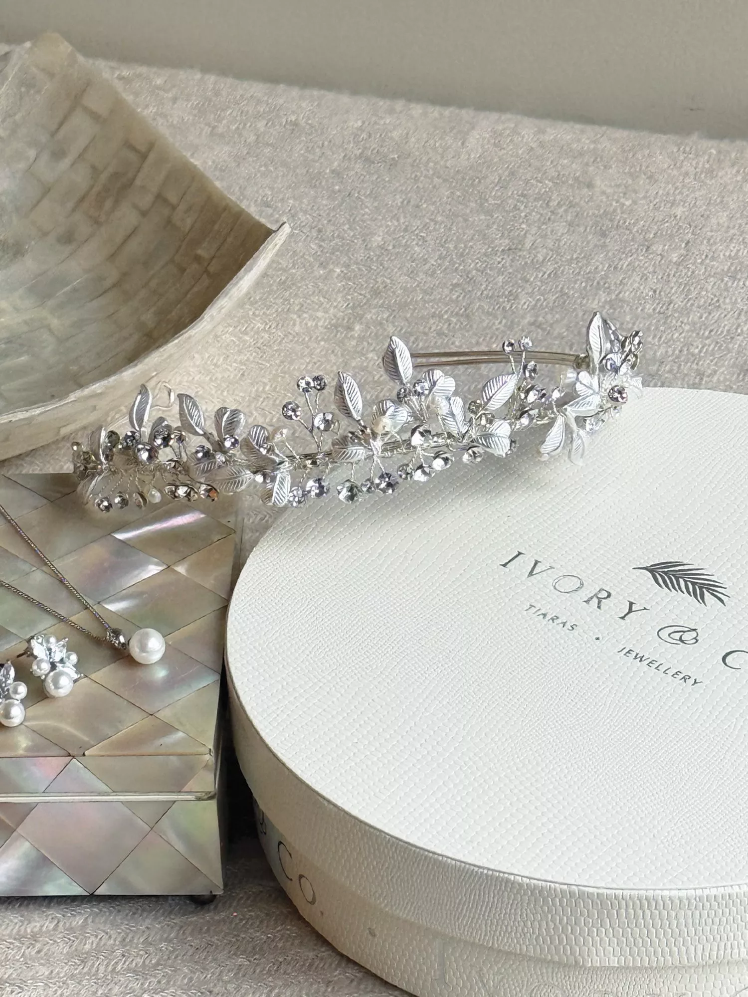 Half-up blonde wedding hairstyle with white floral hair clip, back view, elegant bridal hair accessory