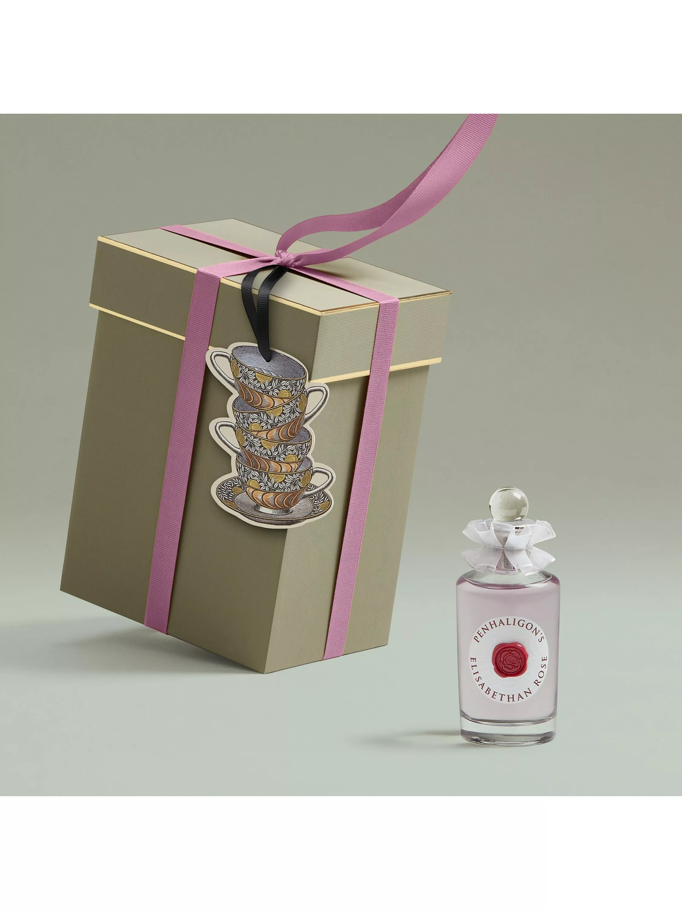 Penhaligon’s Elisabethan Rose perfume bottle beside sage gift box with pink ribbon and teacup charm tag