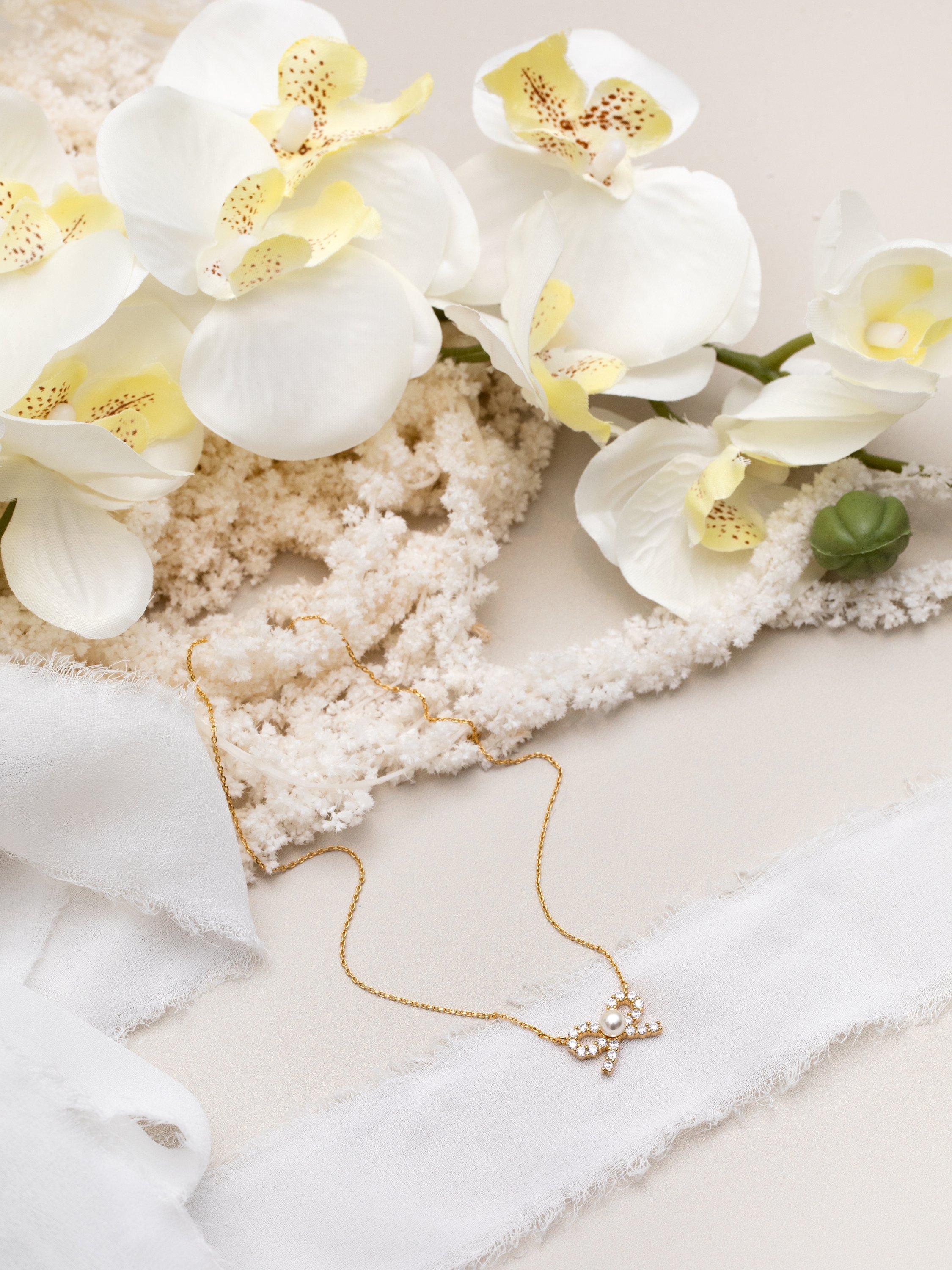 Product image 4 of 5, which shows Orelia Pearl & Crystal Bow Charm Necklace, Pale Gold
