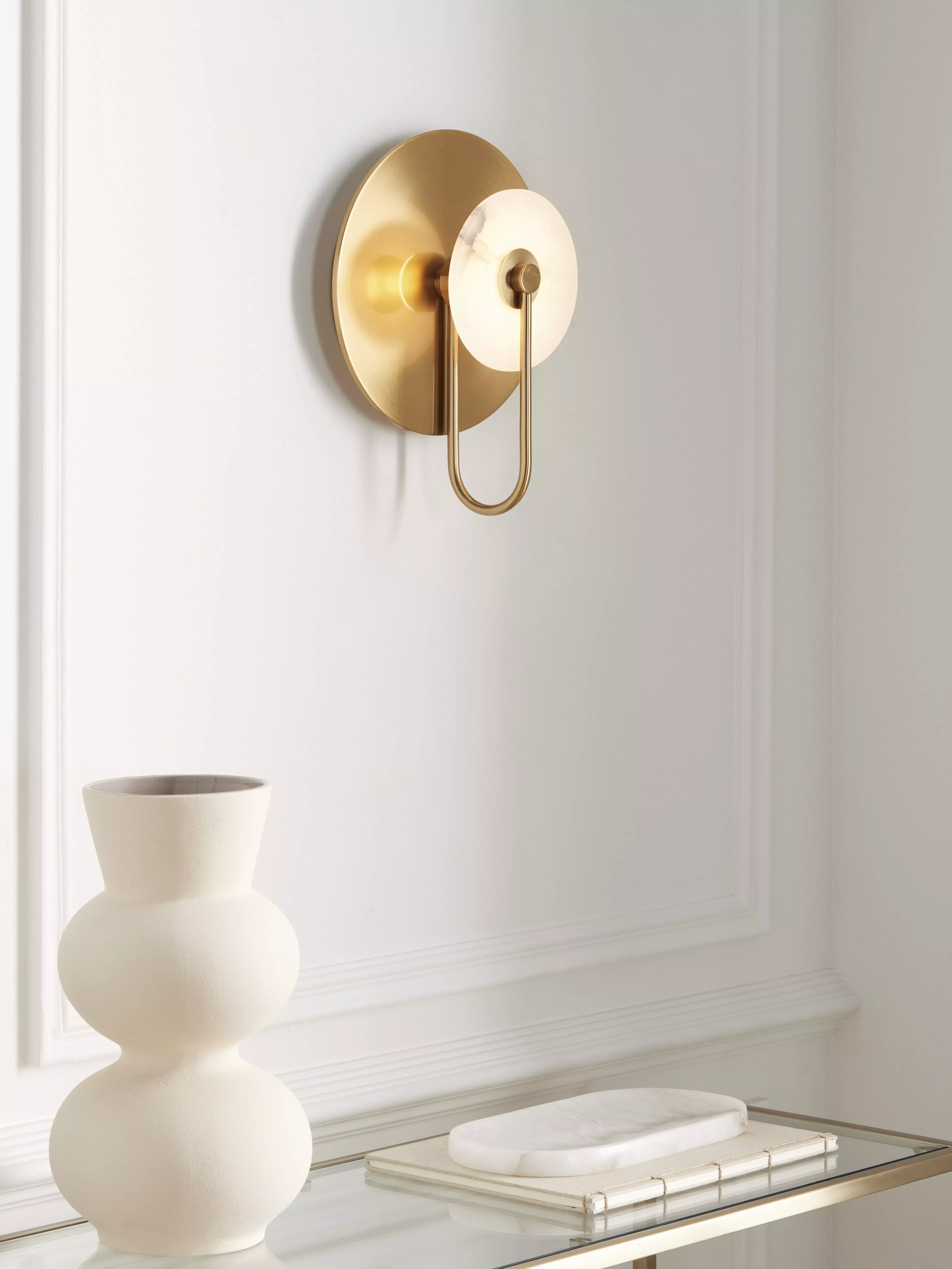 Bronze light fitting with cream lampshade on a red wall 