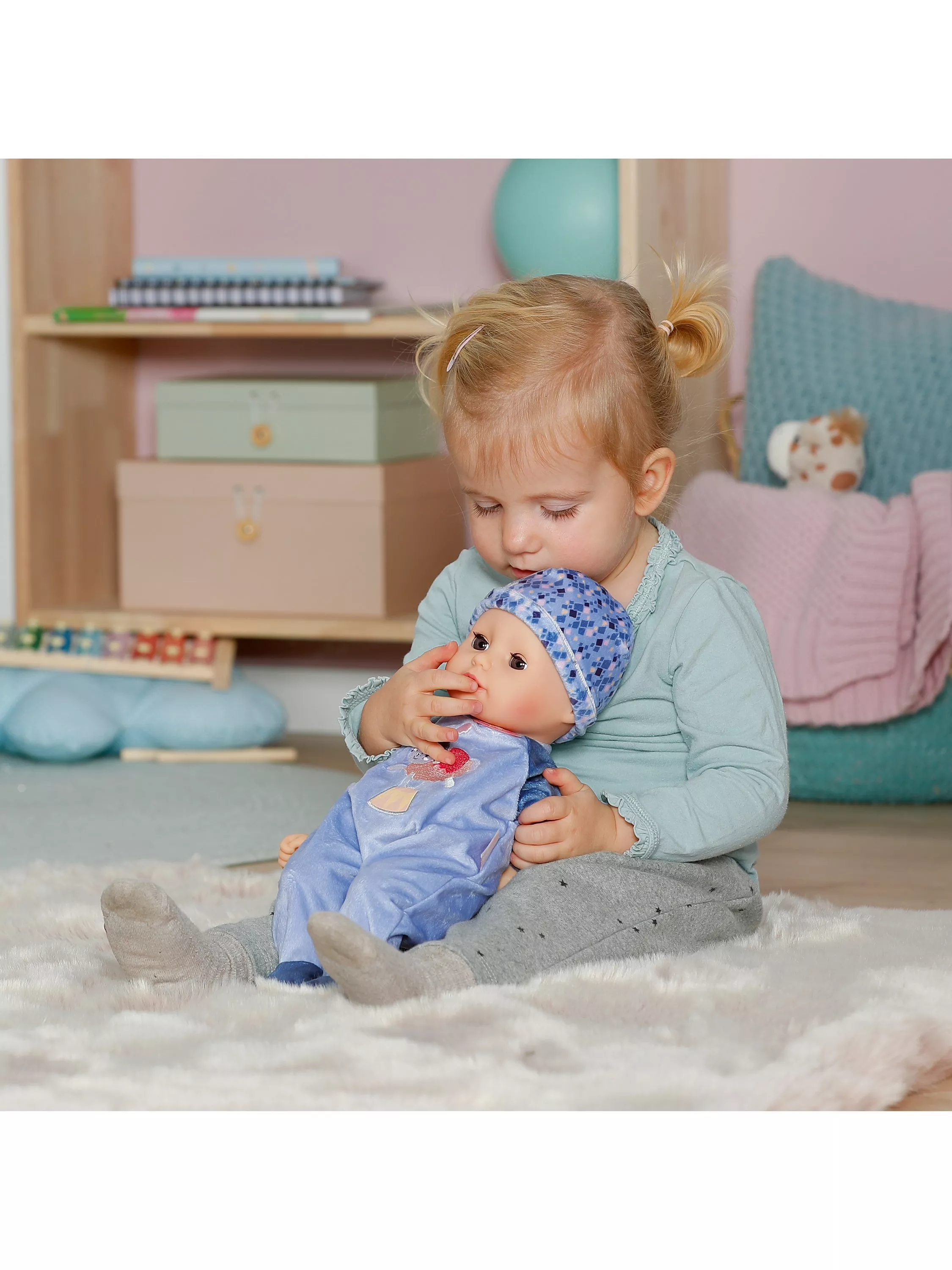 girl holding plastic doll in purple outfit