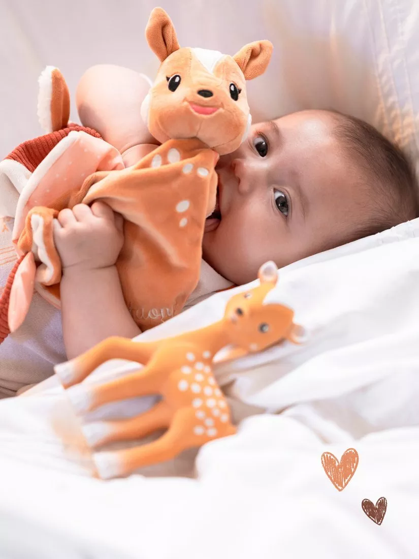 Baby playing with a soft toy comfrter