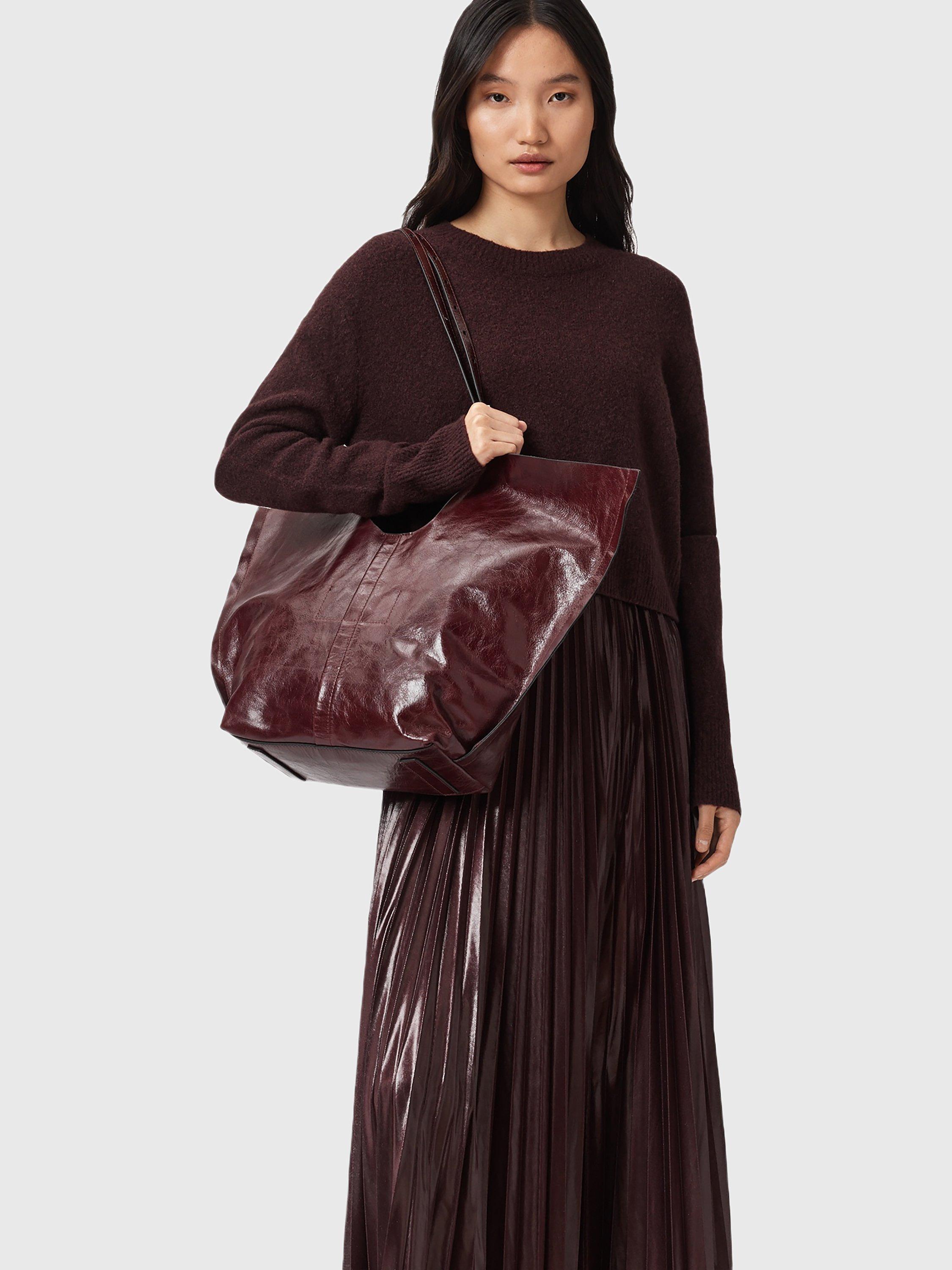 Product image 2 of 7, which shows AllSaints Ara Leather Tote Bag, Dark Red