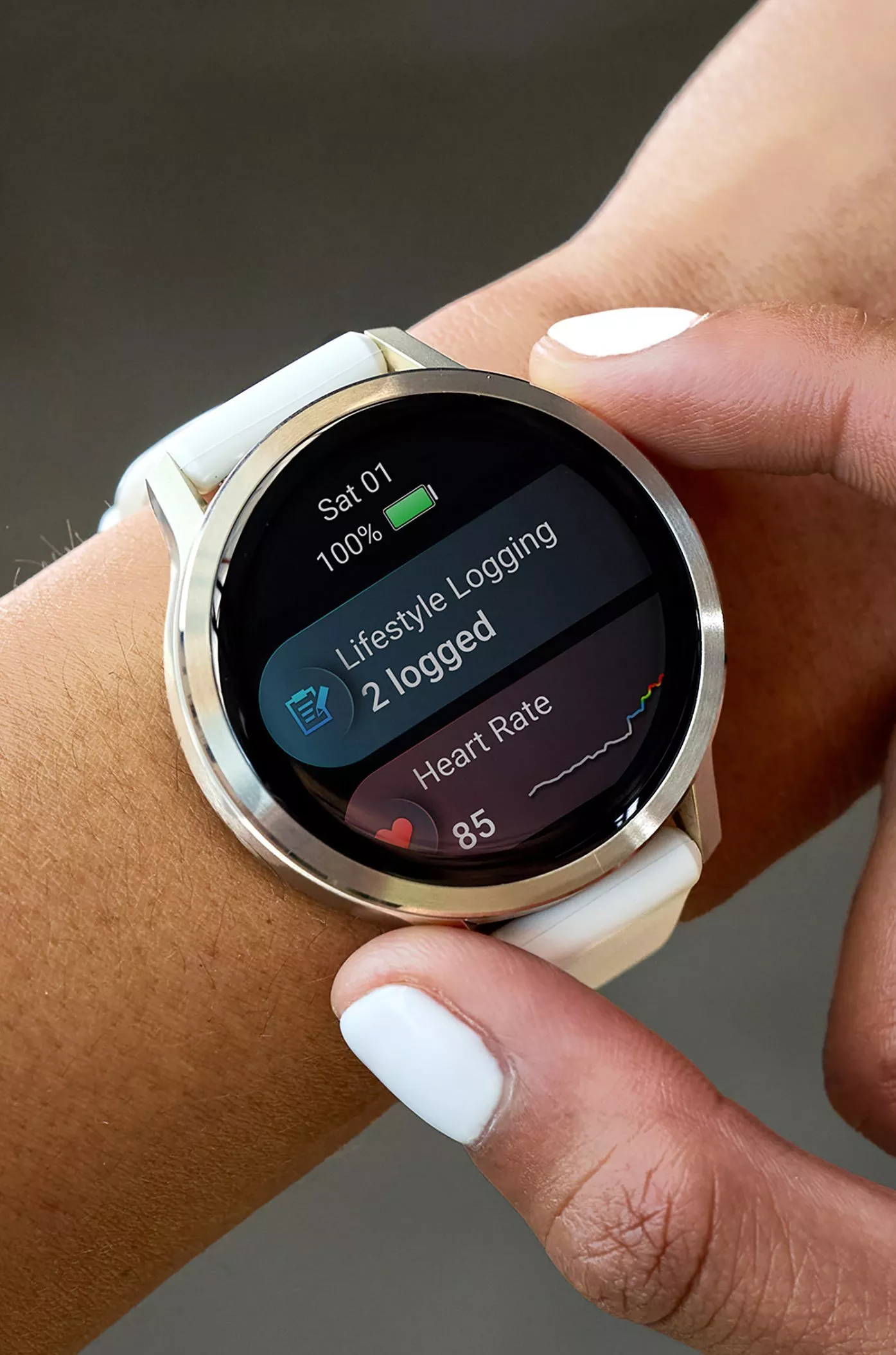 Close-up of smartwatch on wrist showing lifestyle logging and heart rate tracking, white strap and touch screen display