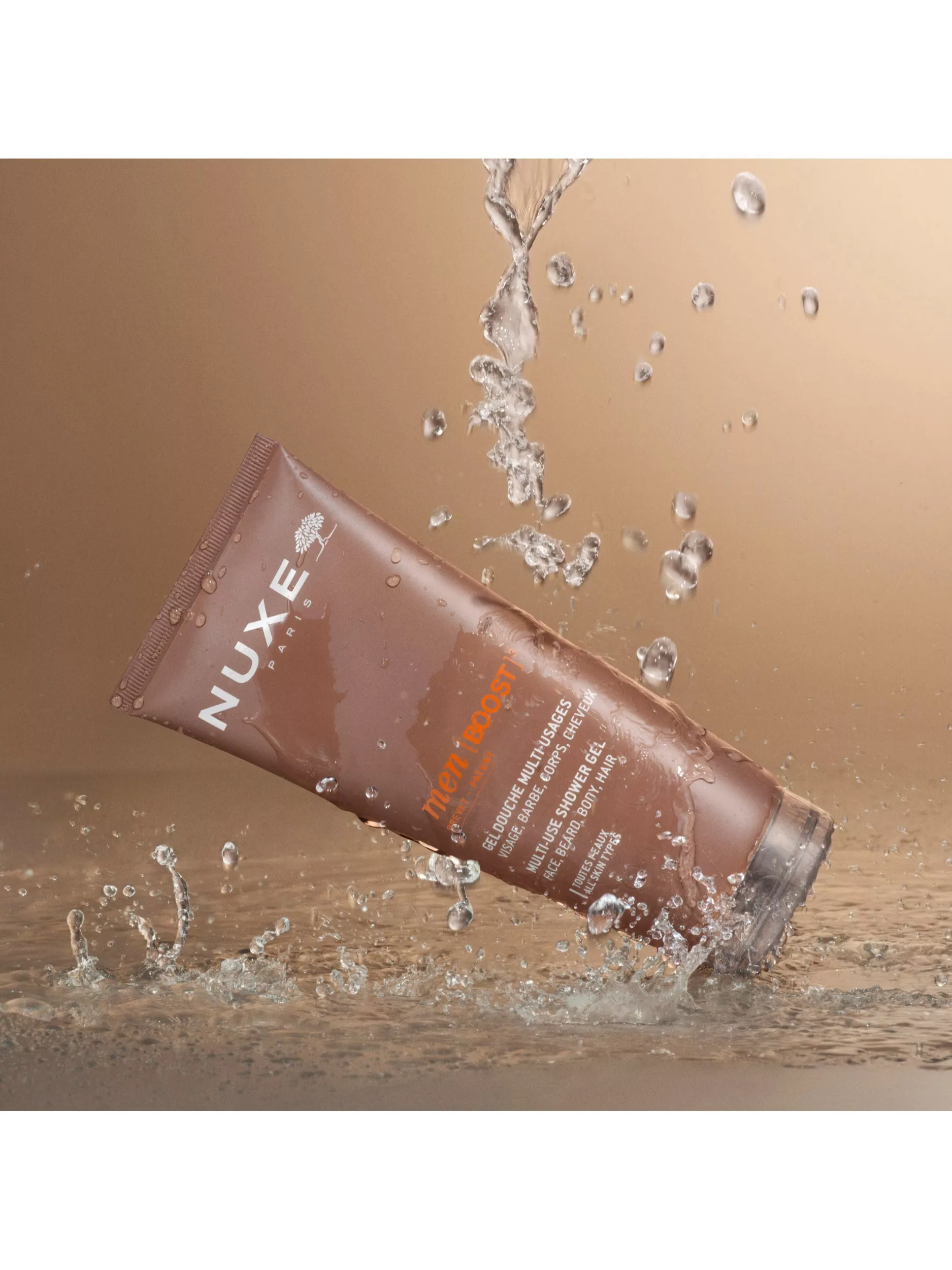 NUXE Men Boost multi-use shower gel tube splashing in water, skincare and body wash product close-up