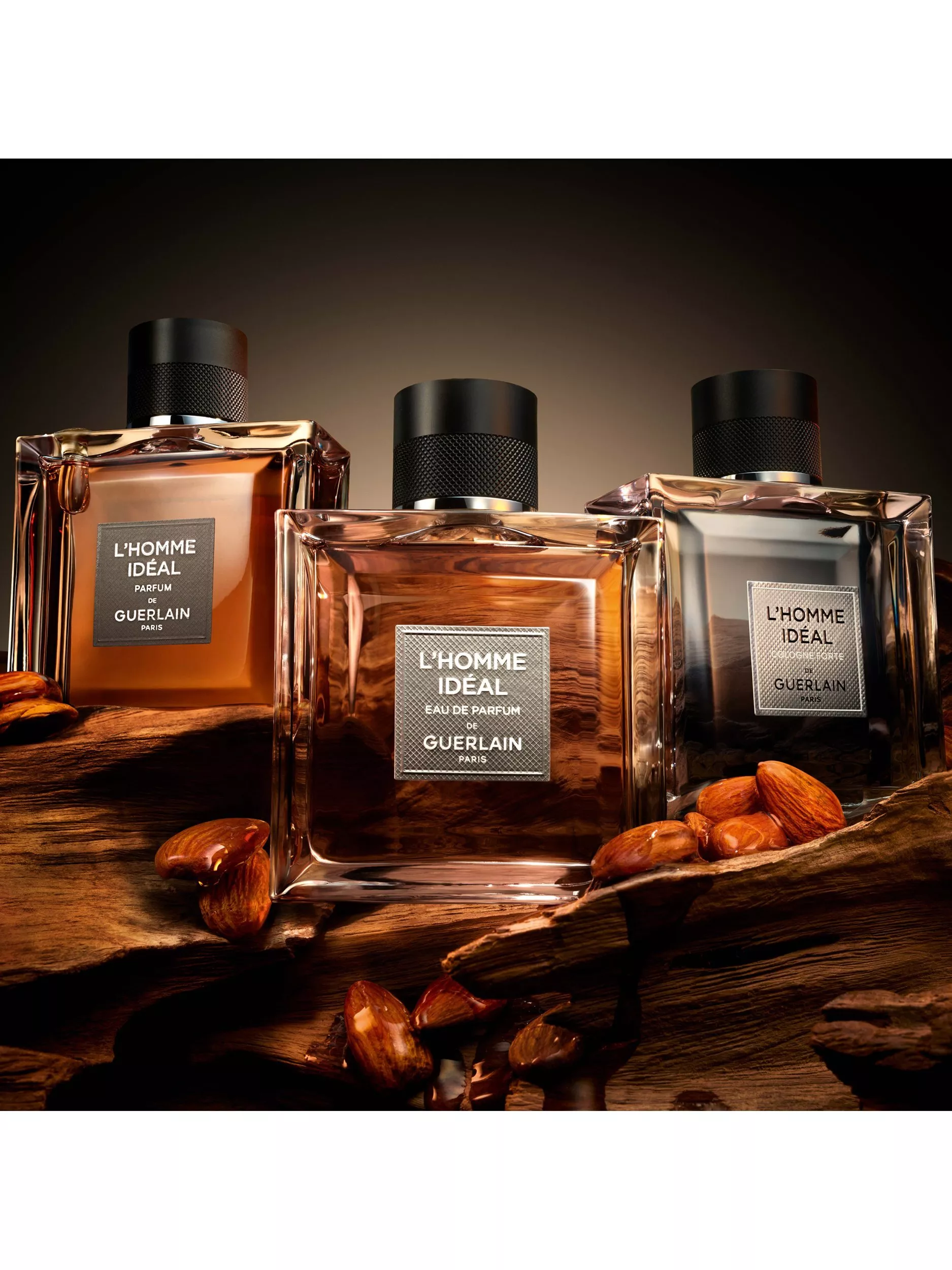 Guerlain L’Homme Idéal men’s fragrance bottles on wooden surface with almonds, luxury perfume product photo