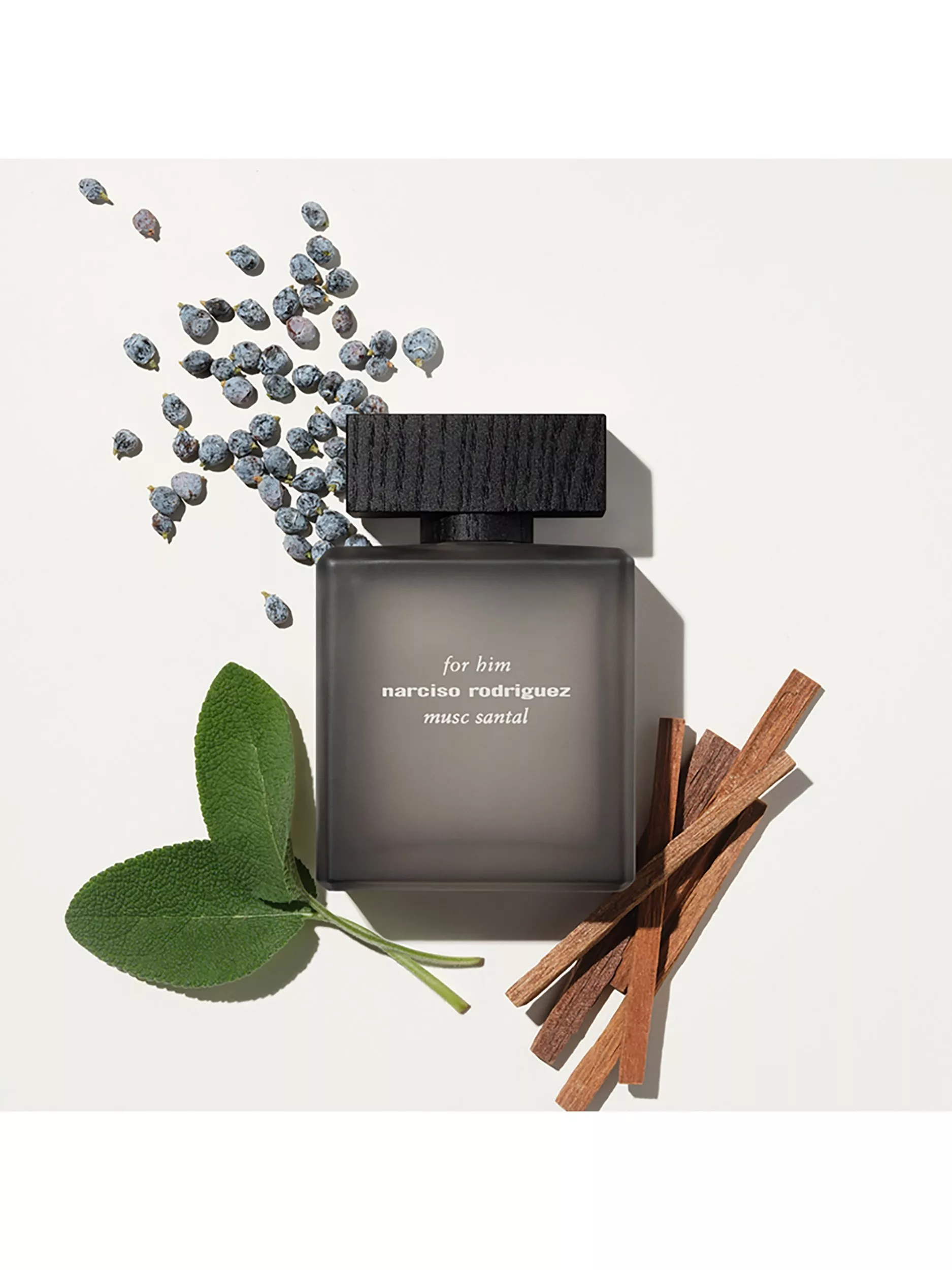 Narciso Rodriguez For Him Musc Santal eau de parfum bottle with berries, sage leaves and sandalwood sticks