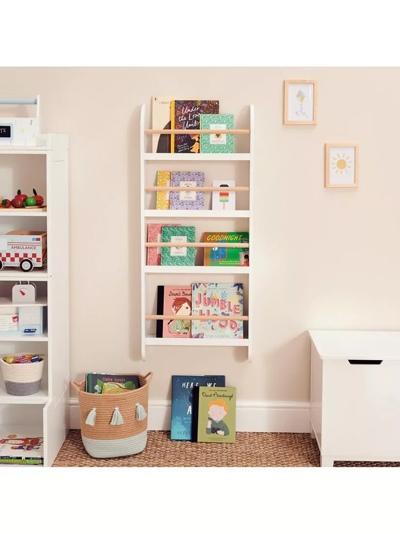 White wall-mounted children's book rack with colourful storybooks in a bright, tidy nursery reading corner