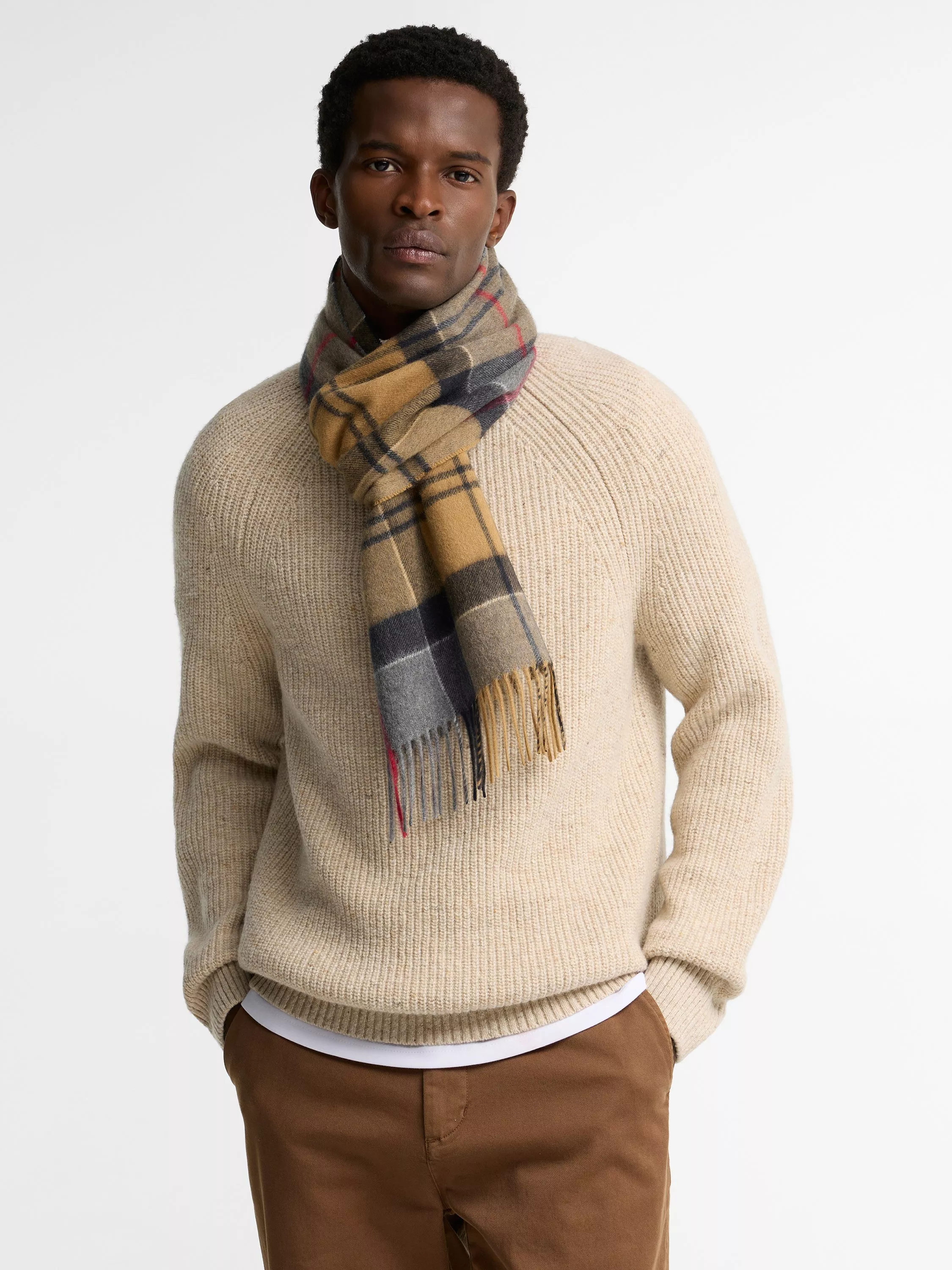 Man wearing a tartan checked cashmere scarf with beige jumper