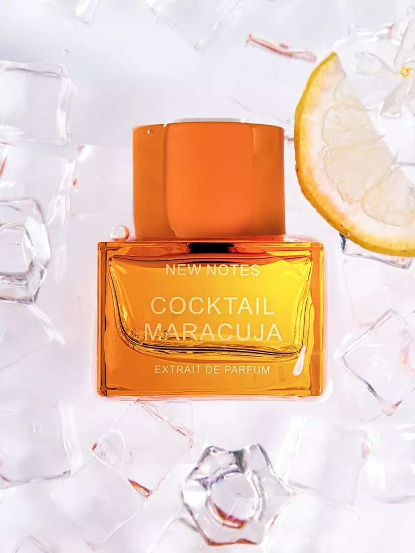 New Notes Cocktail Maracuja extrait de parfum bottle on ice cubes with lemon slice, bright citrus fragrance photo