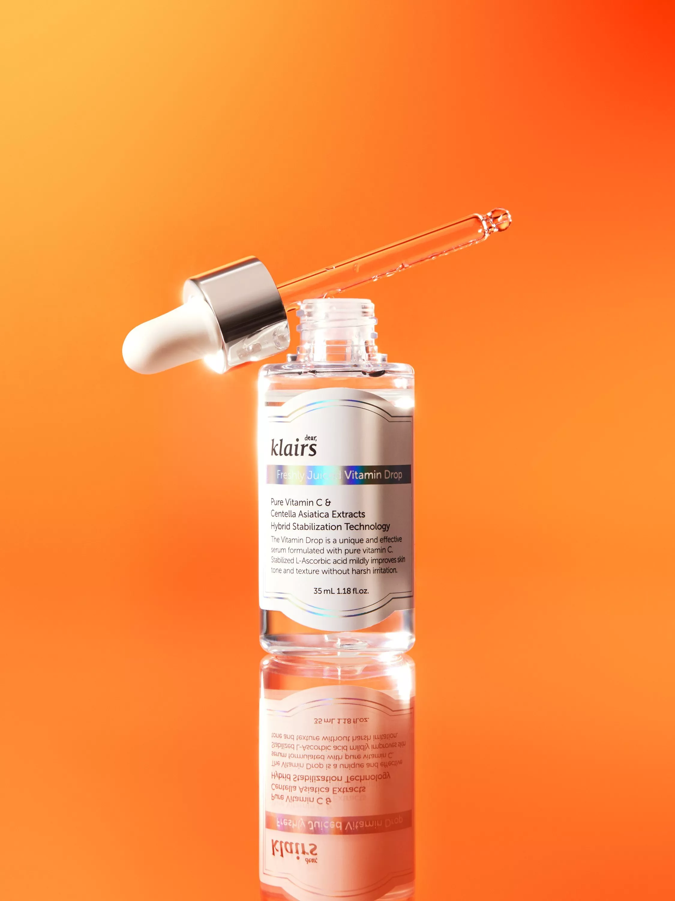 Klairs Freshly Juiced Vitamin Drop serum bottle with dropper on orange background, skincare product close-up