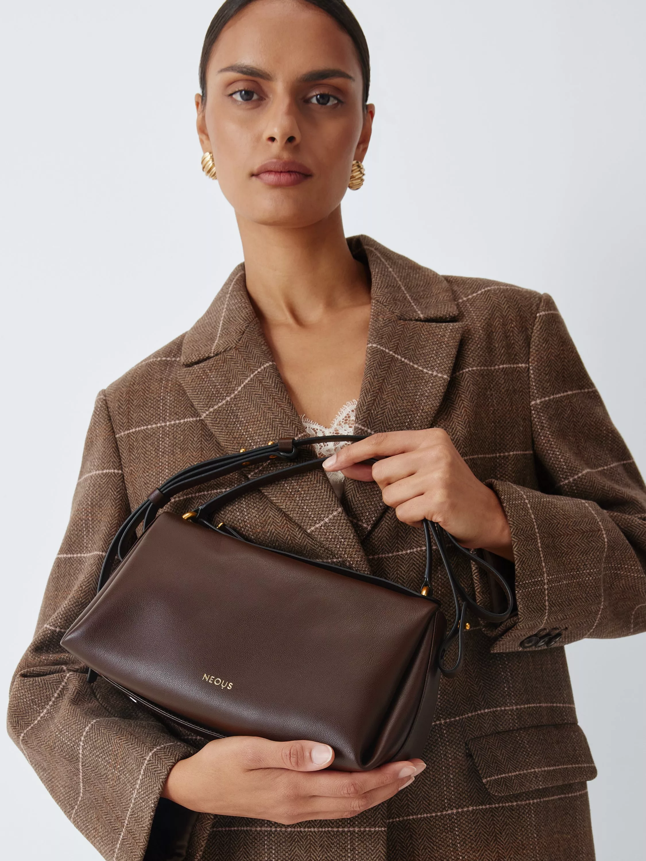 Woman carrying a large black tote bag with brown leather handles, stylish everyday shoulder bag for travel and shopping