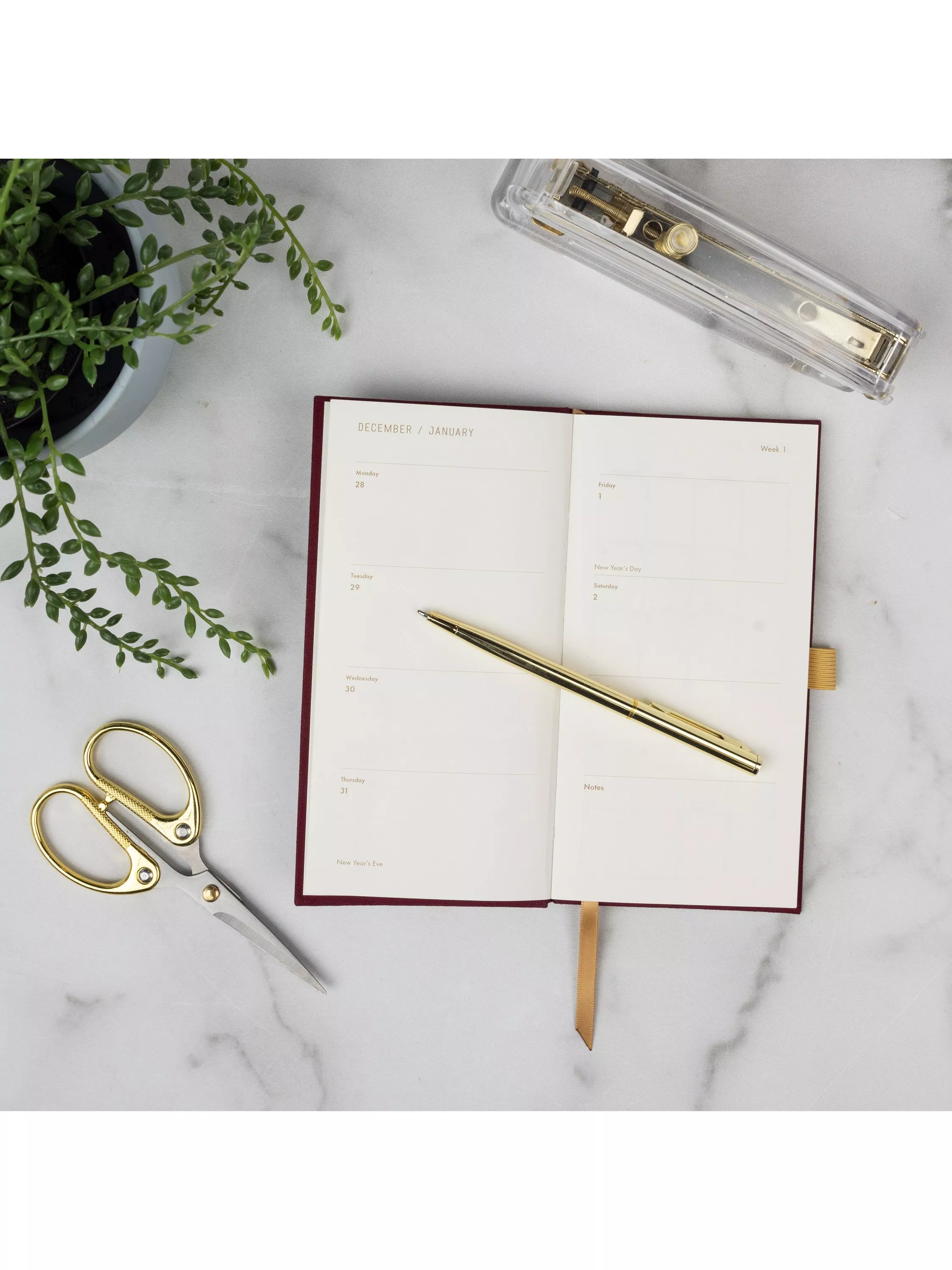 Diary on a table with coffee laptop and plant