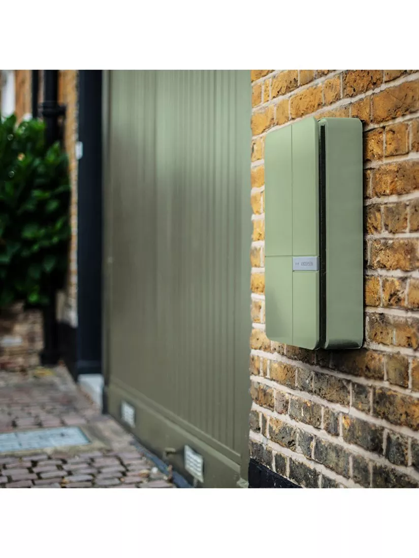 Wall-mounted smart parcel delivery box on brick wall by front gate, secure home package drop-off solution