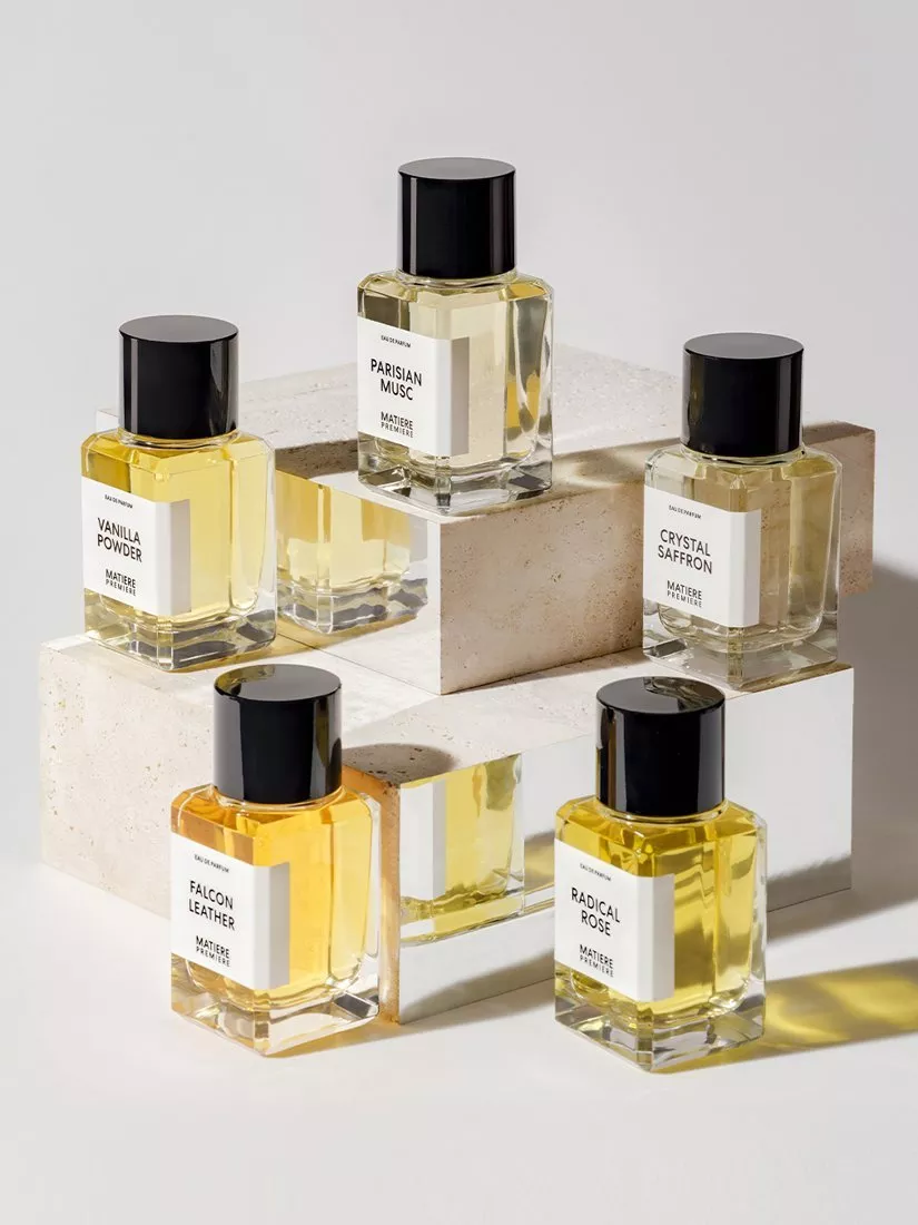 Luxury perfume bottles with black caps on stone blocks, showcasing niche fragrance collection in studio light