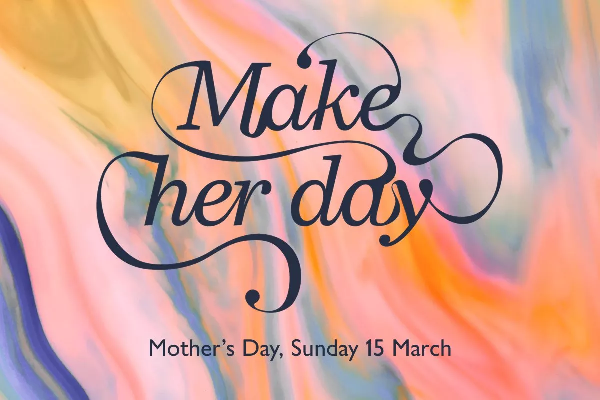 Elegant script "Make her day" on a colourful, swirling pastel background, creating a cheerful and uplifting vibe.