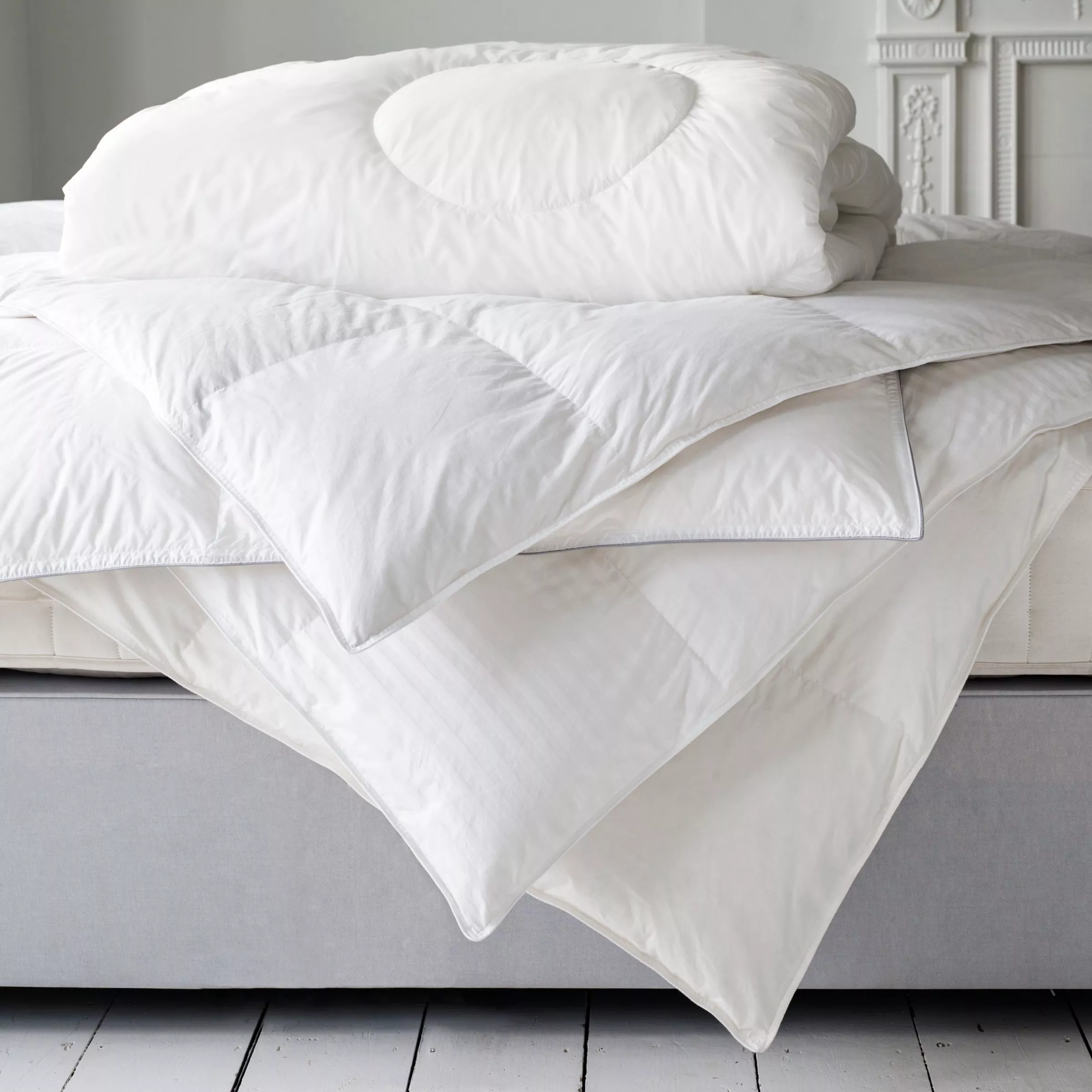 White pillow on a bed with a rattan headboard, beside a textured lamp, creating a cosy bedroom atmosphere.