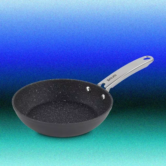 Non-stick frying pan with speckled interior and stainless steel handle, shown on a blue gradient background