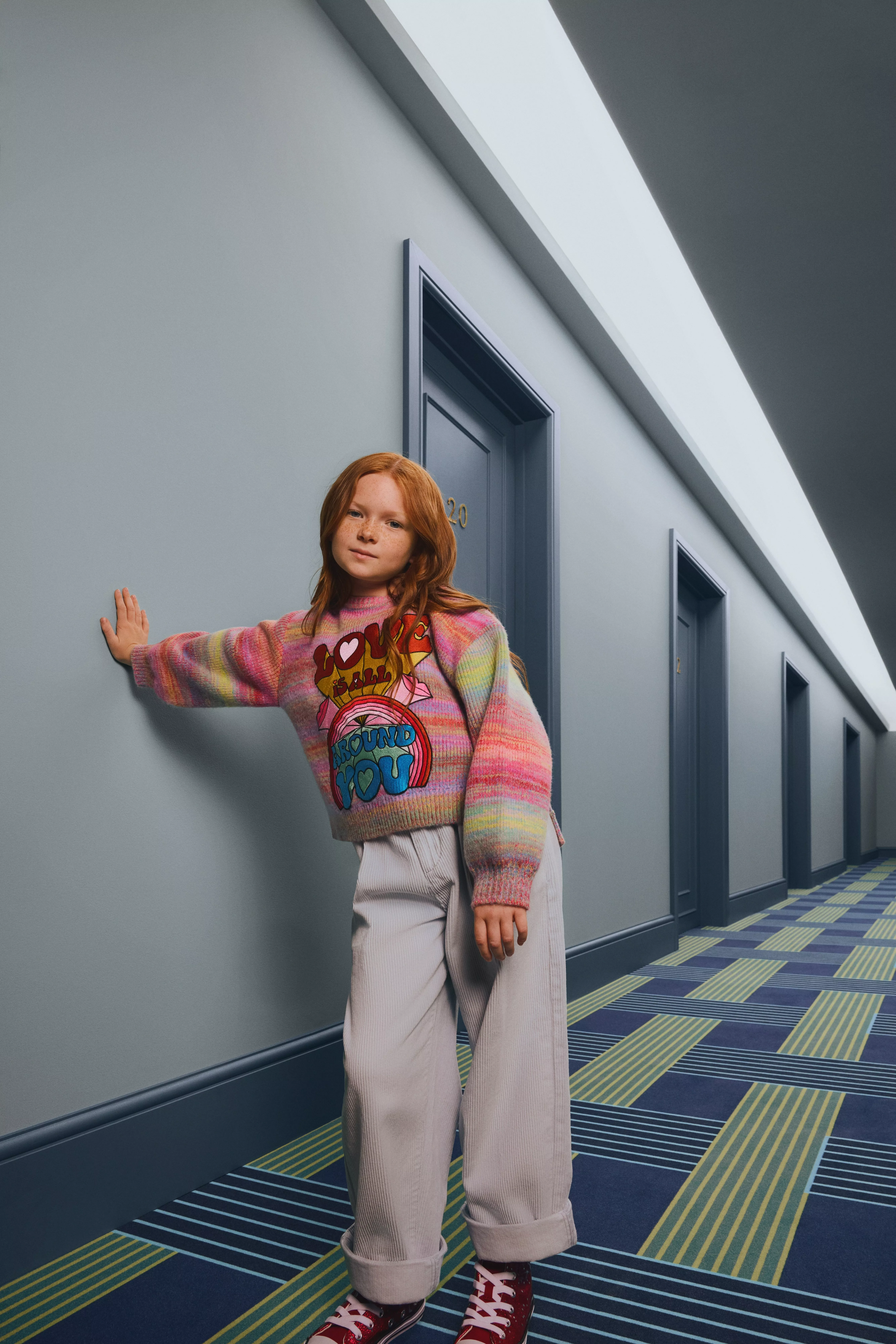 girl wearing a multicoloured stripe jumper and trousers