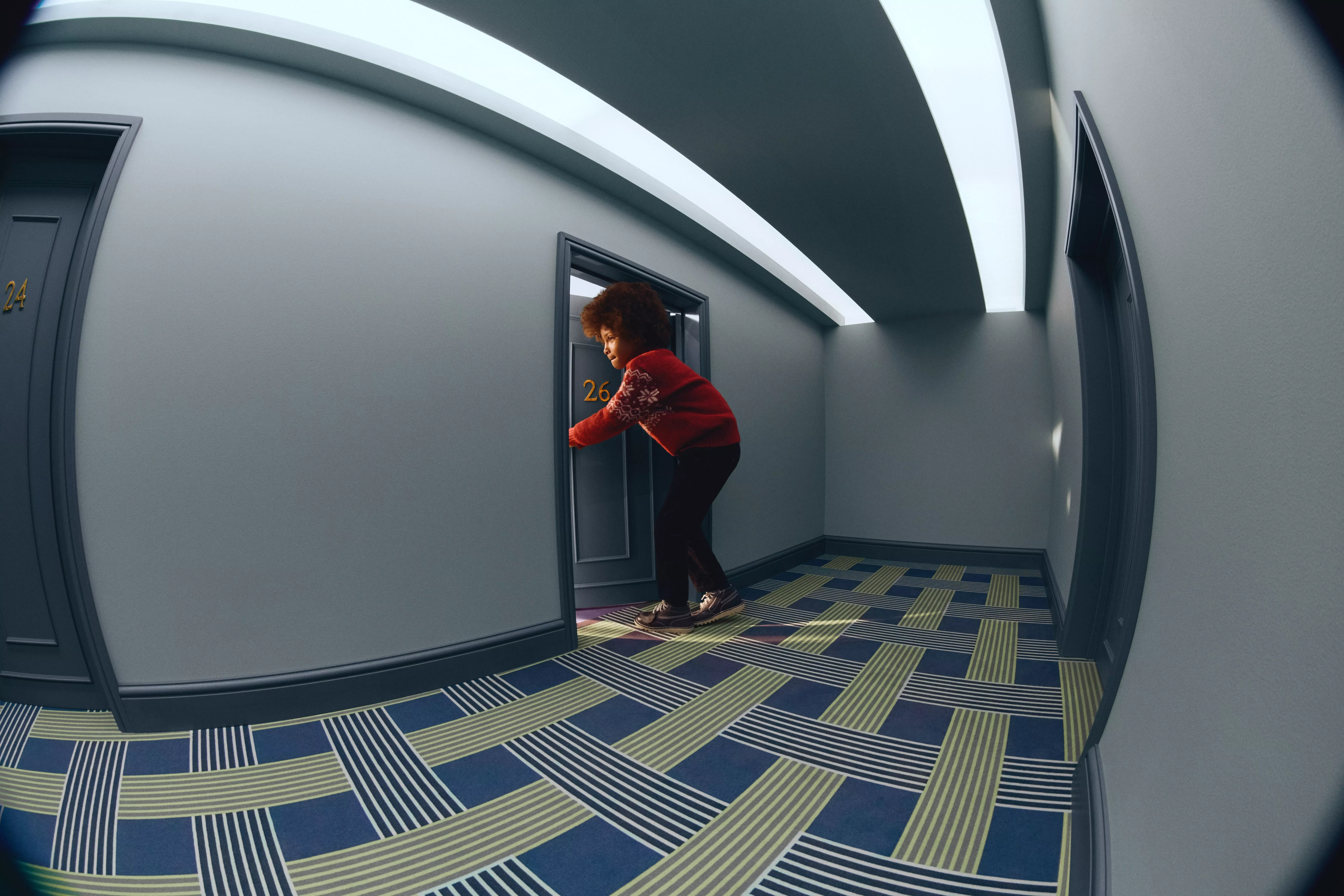 boy wearing a red jumper and black trousers going through a door