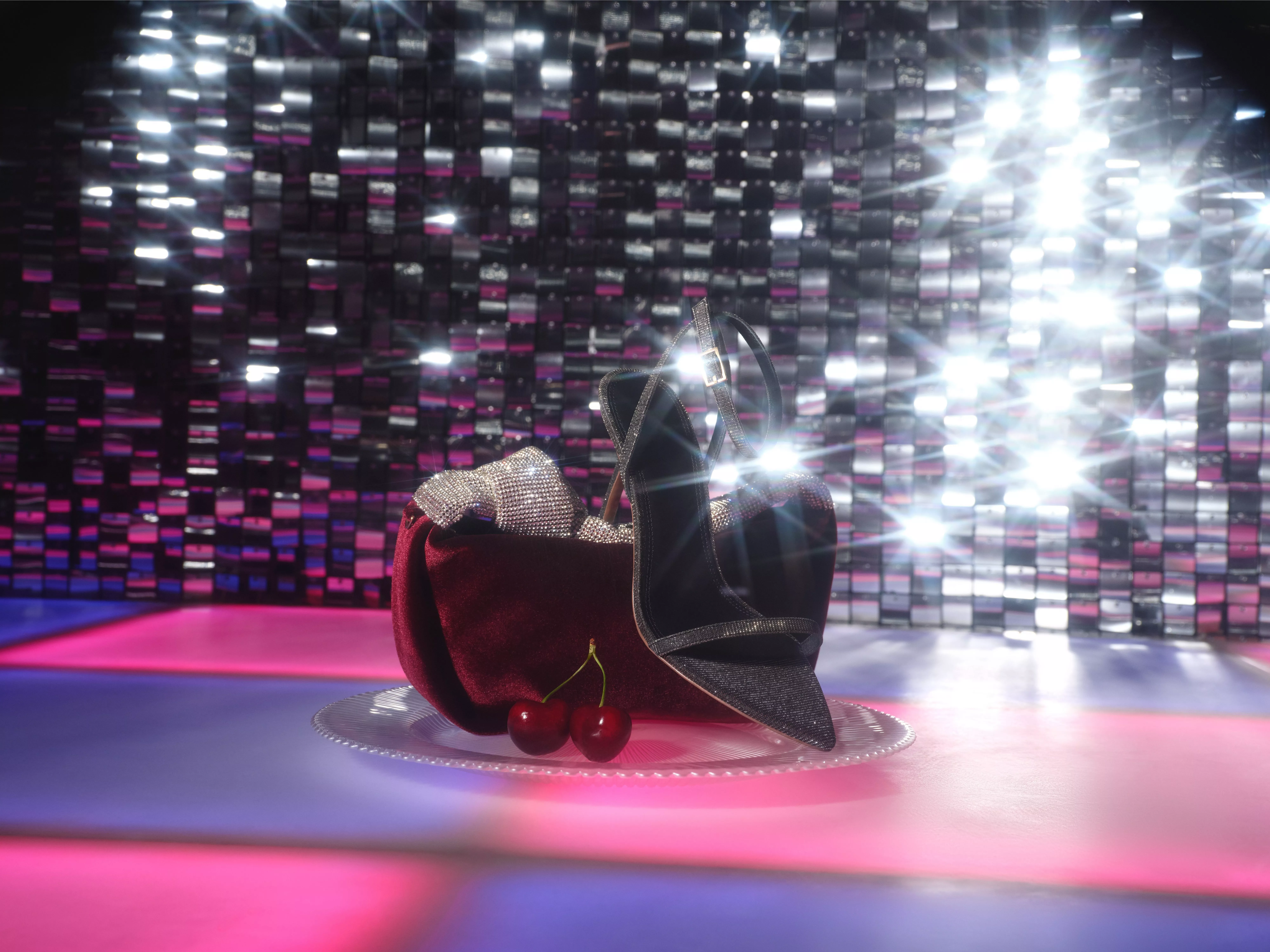 black sparkly strappy heels in front of a bag and sequin background