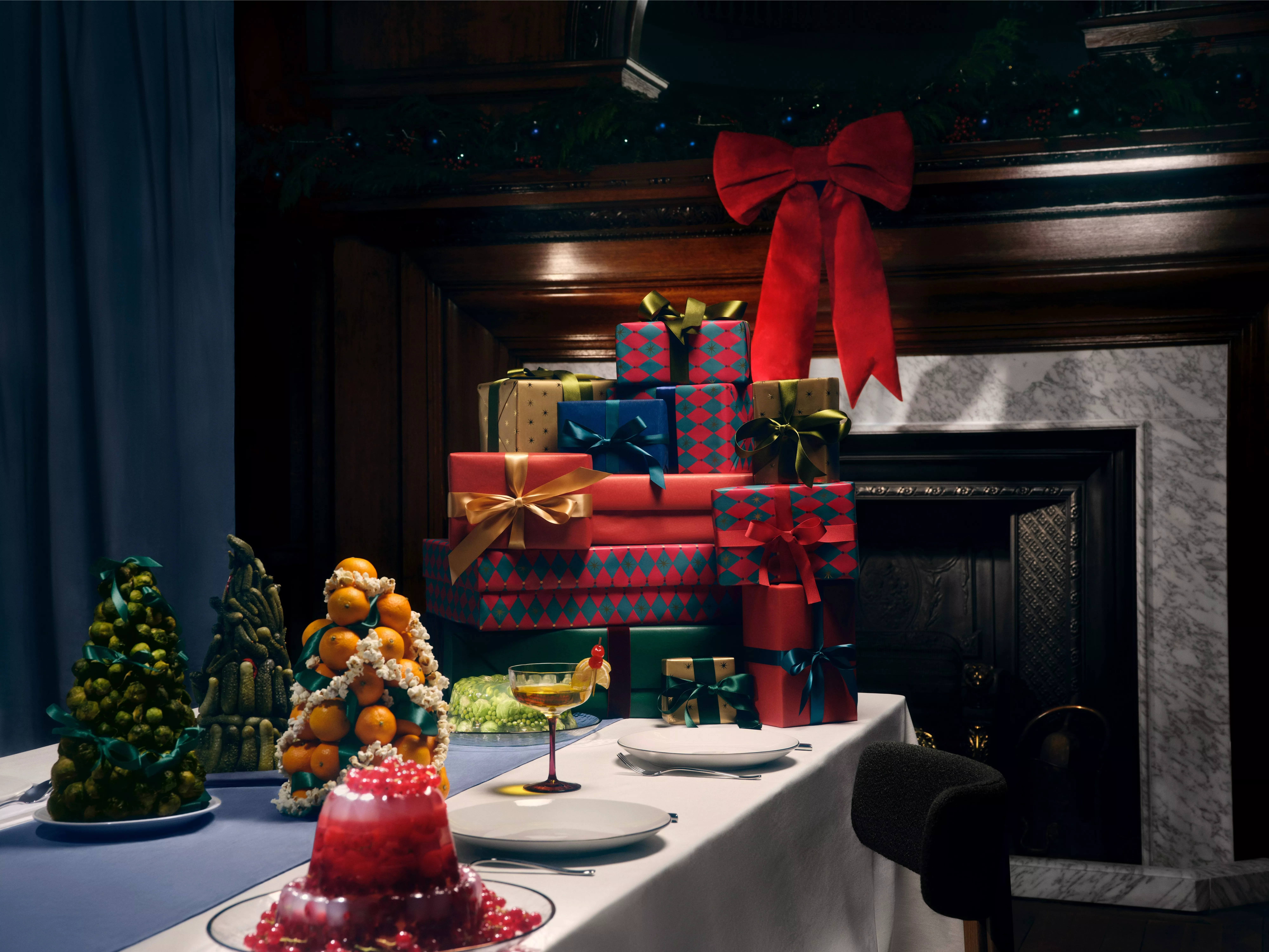 A pile of wrapped gifts at the end of a dining table