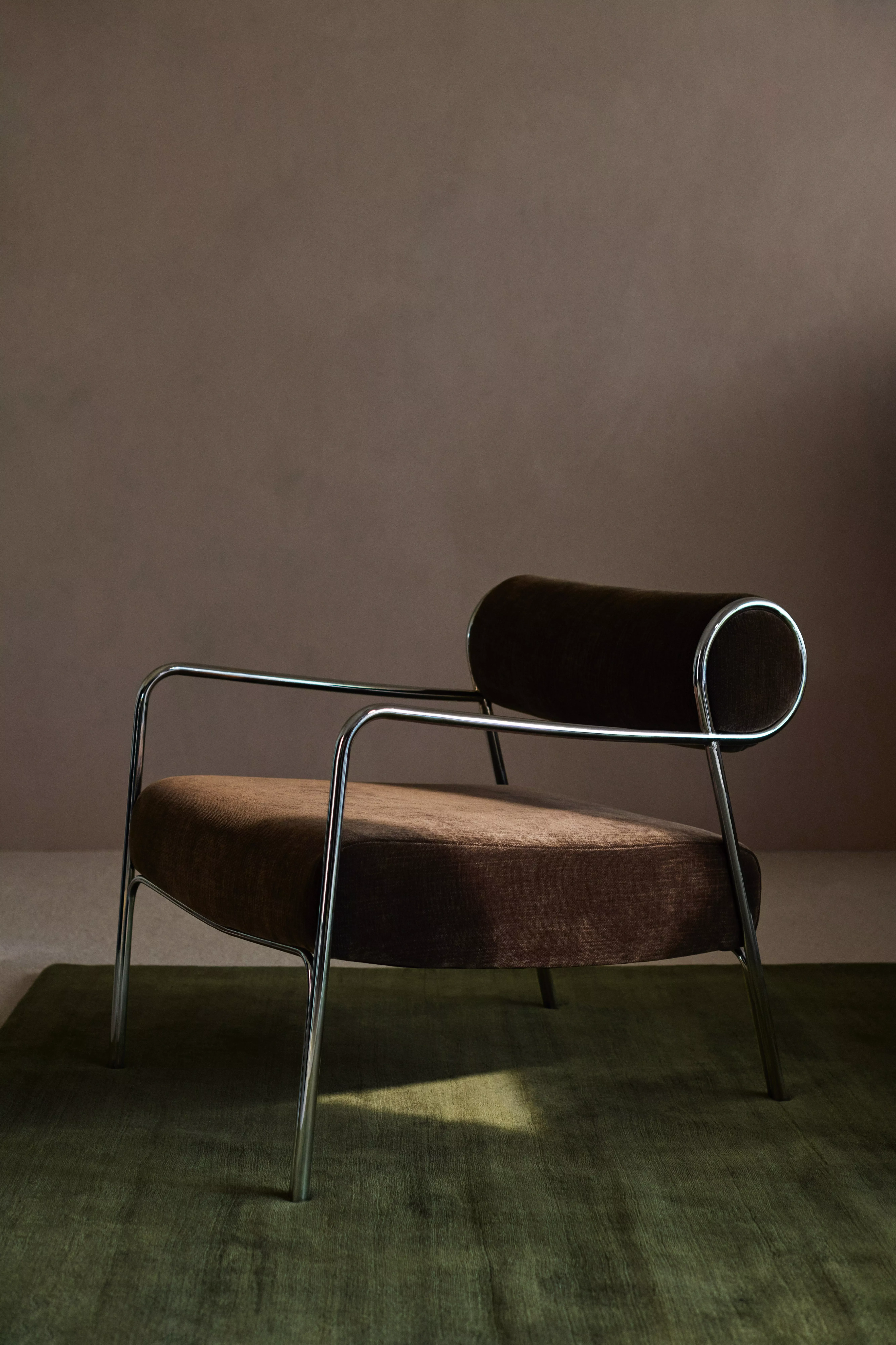 Burgundy chest of drawers with a wicker lamp on top and striped rug on the floor