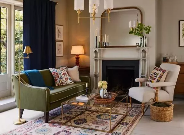 Living room with green sofa and cream armchair next to a fireplace