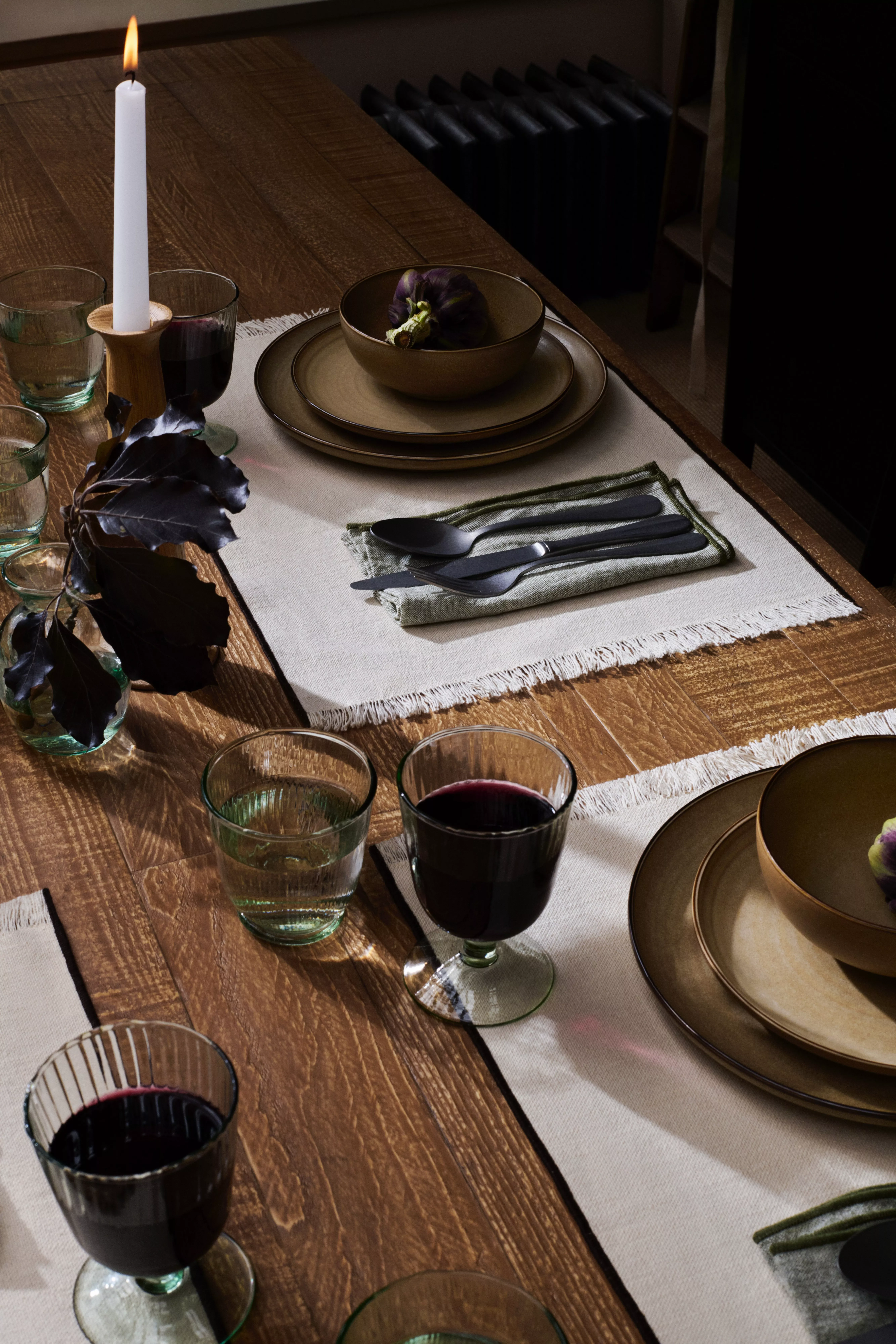 Oak dining table with plates, cutlery and glassware on