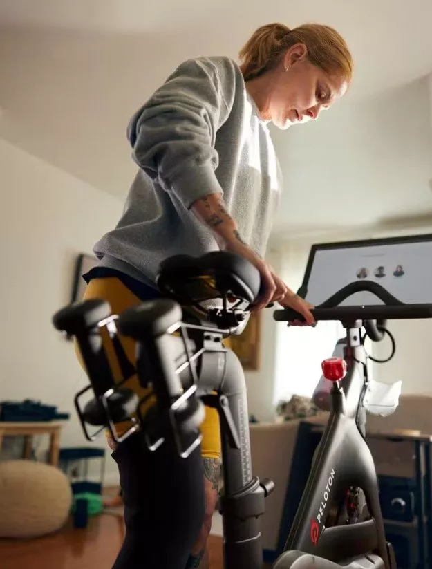 woman getting ready to exercise on a peloton bike 