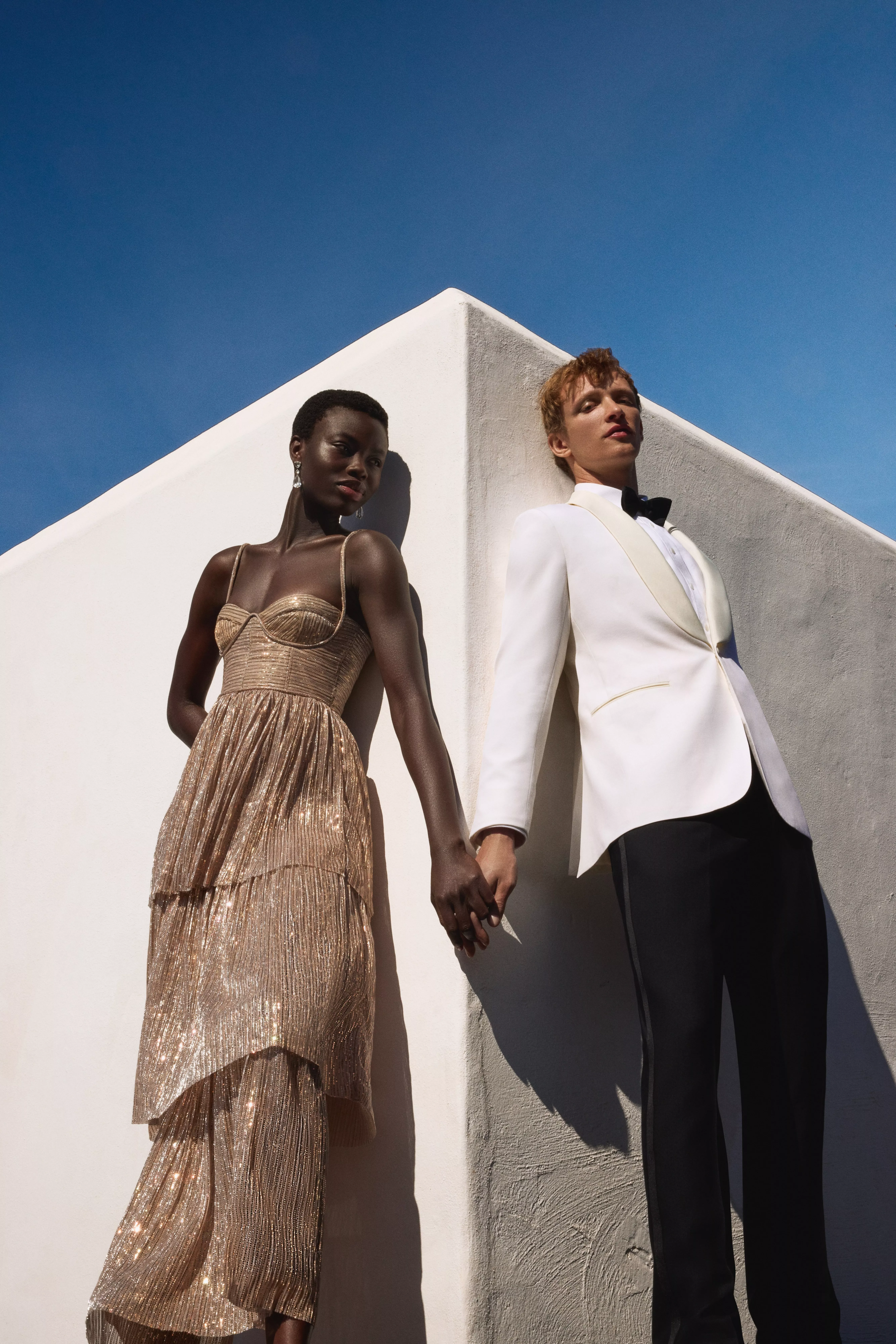 Man wearing rental tuxedo and woman wearing sequin rental dress