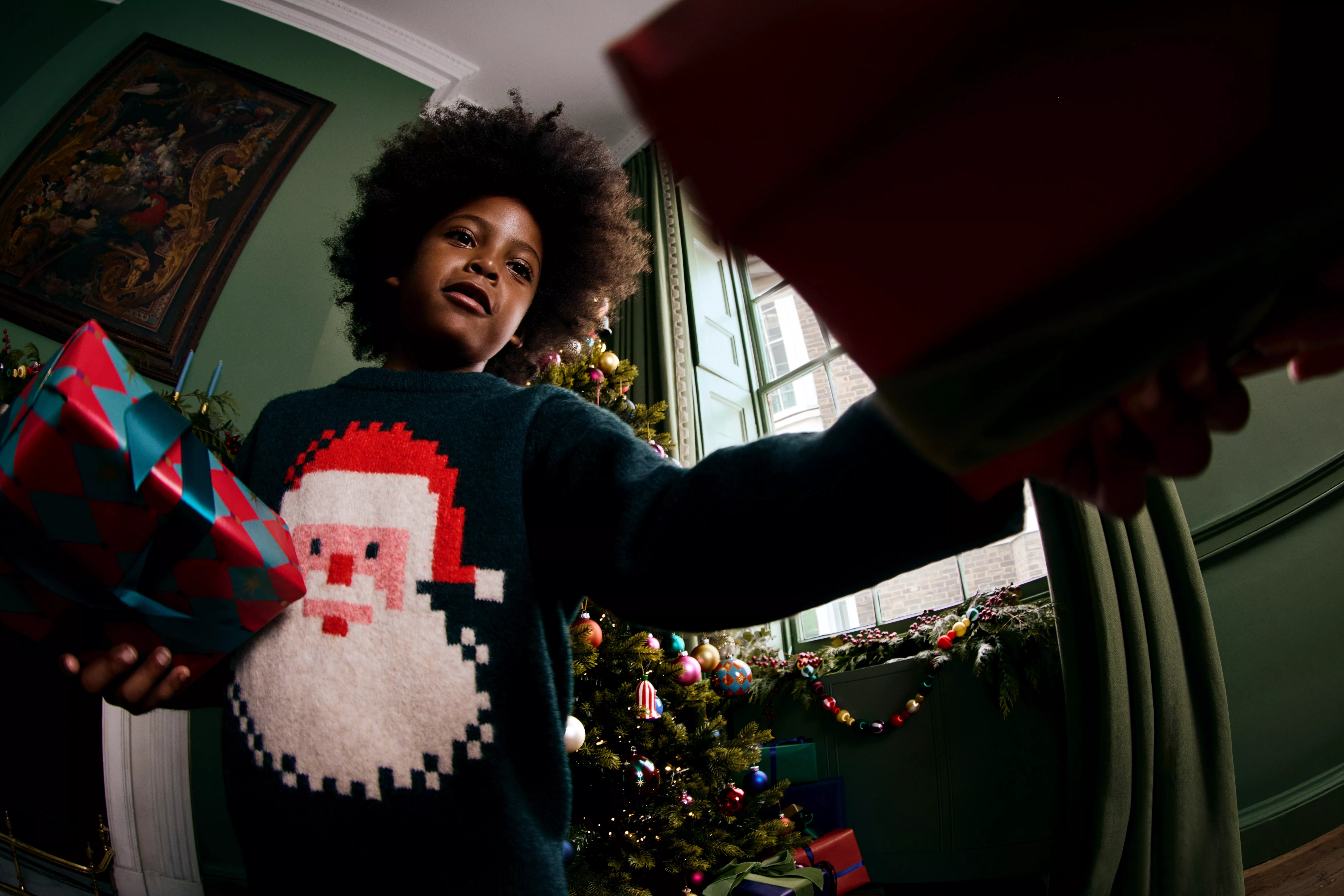 boy wearing a Christmas jumper with a Santa on it