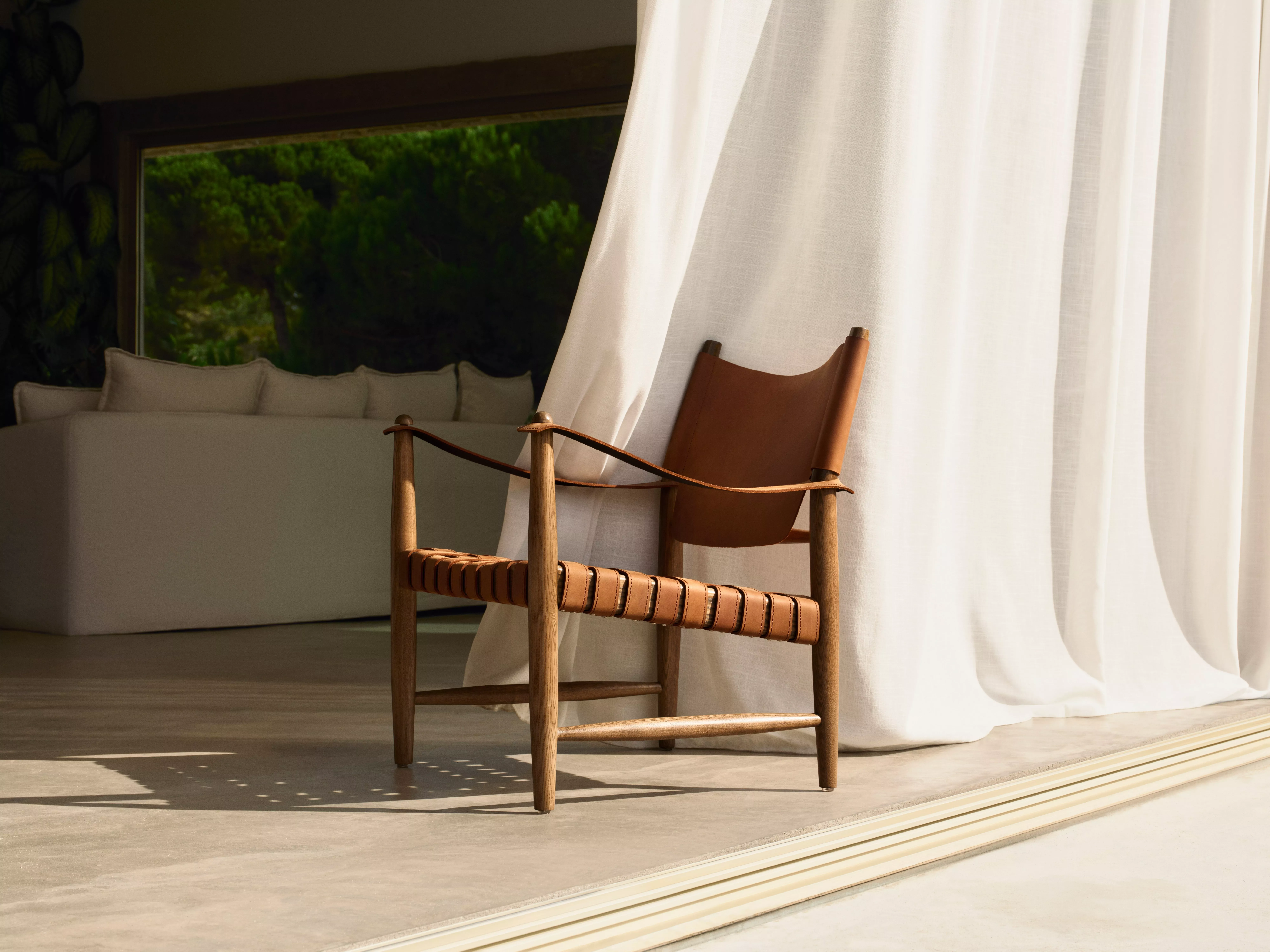 John Lewis rove woven leather armchair in front of a curtain
