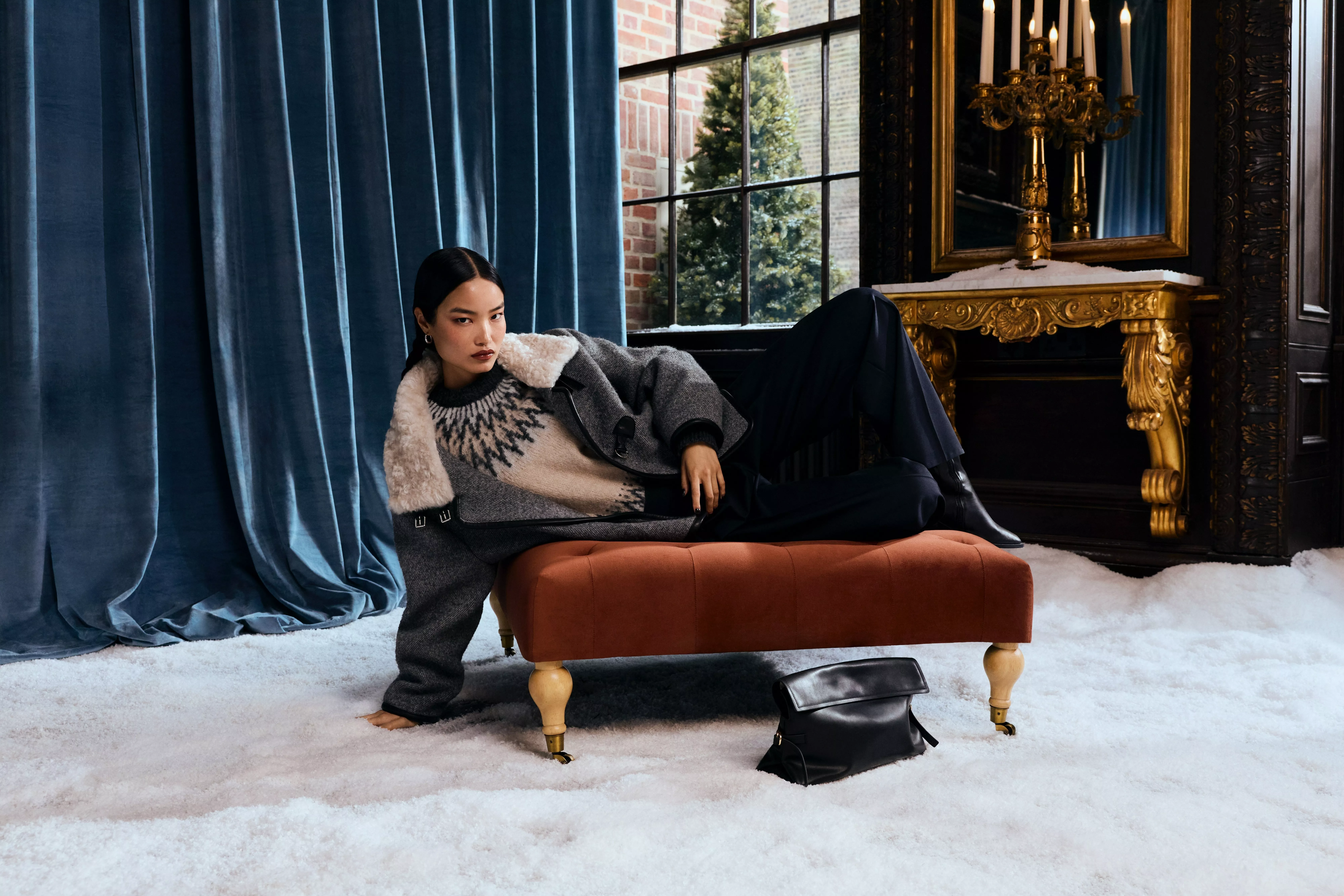 woman on chaise wearing fairisle cream and black jumper and navy trousers