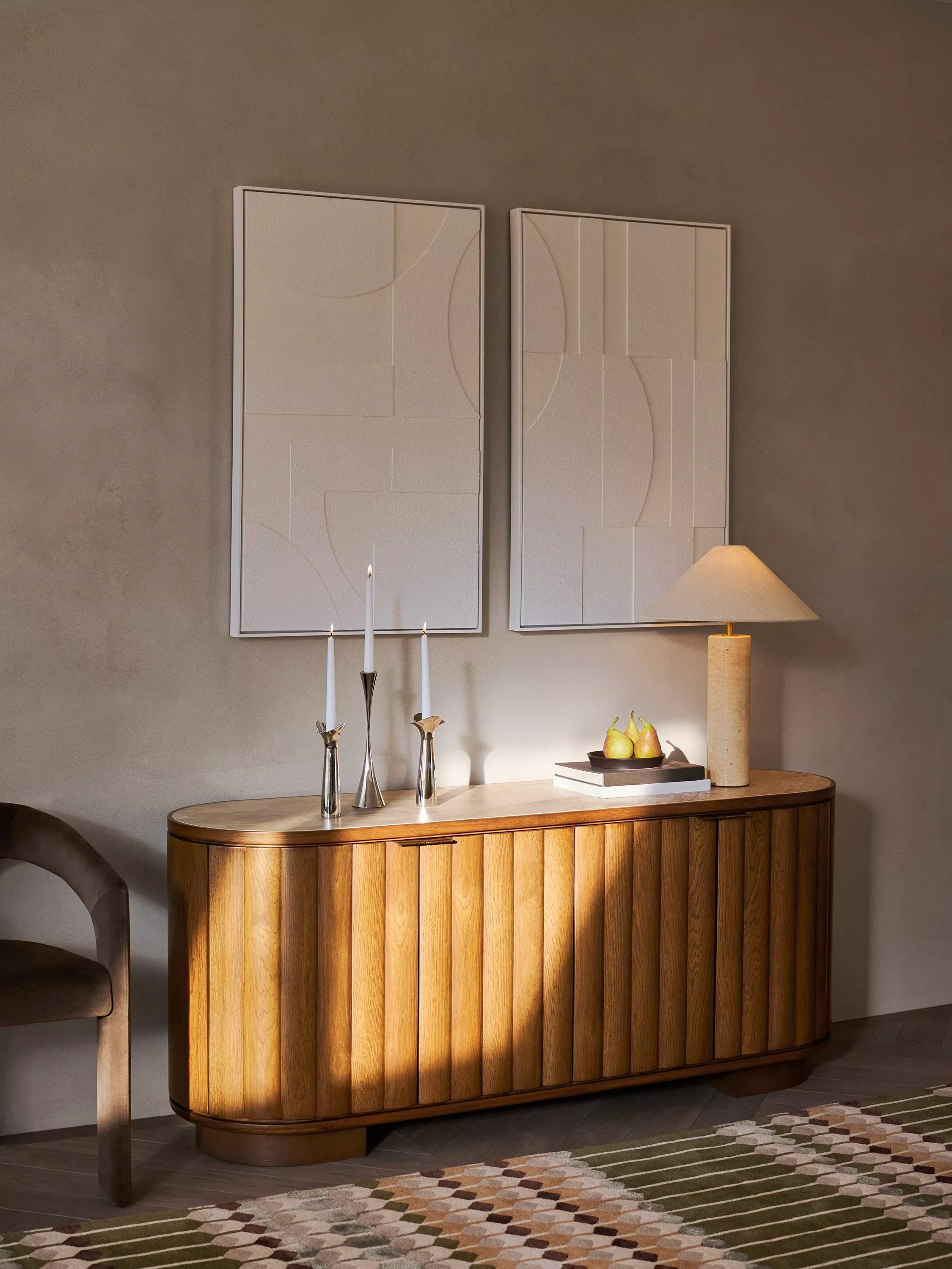 Wooden slatted sideboard with candles and cream lampshade on top 