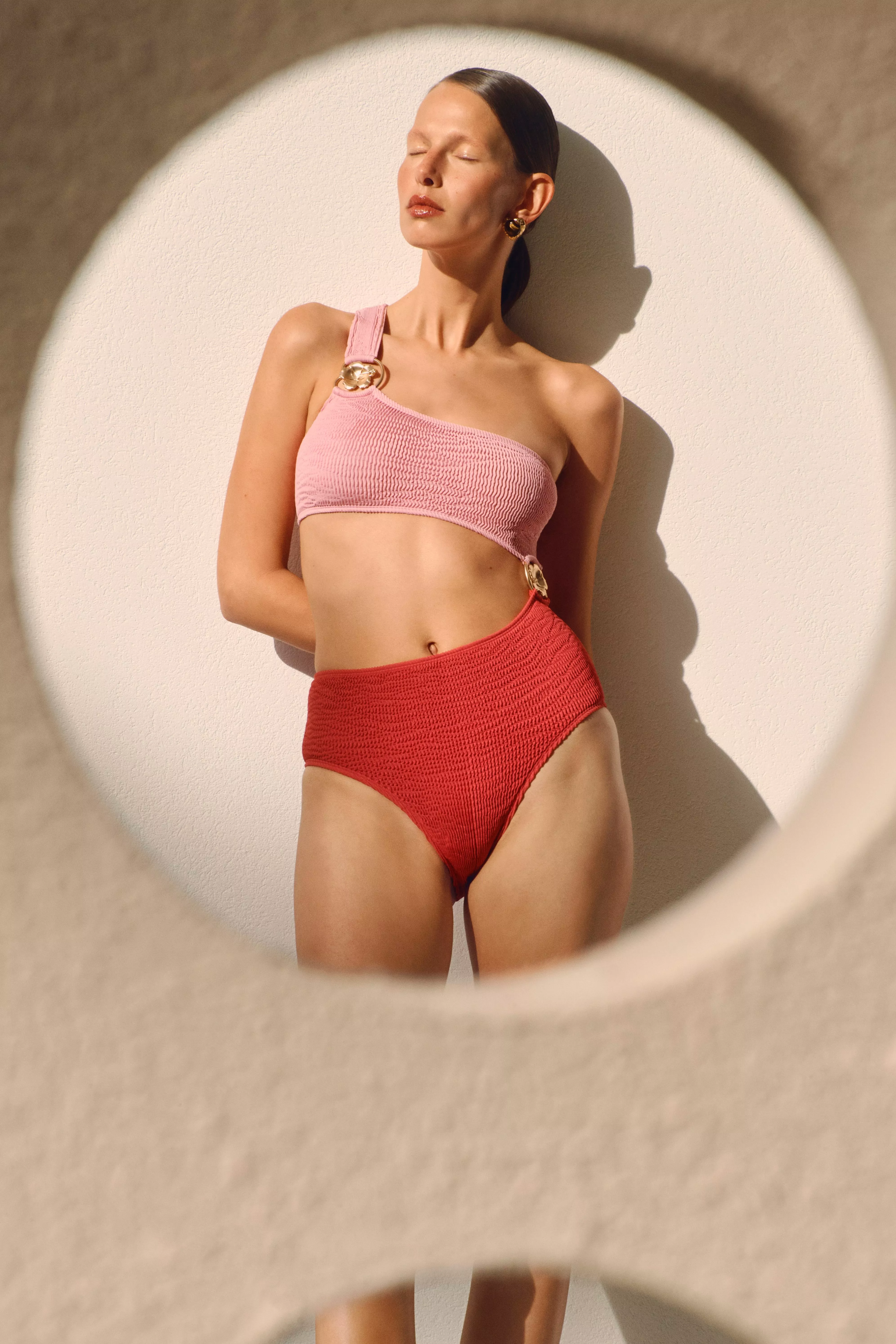 woman in a pink and red cutaway swimsuit