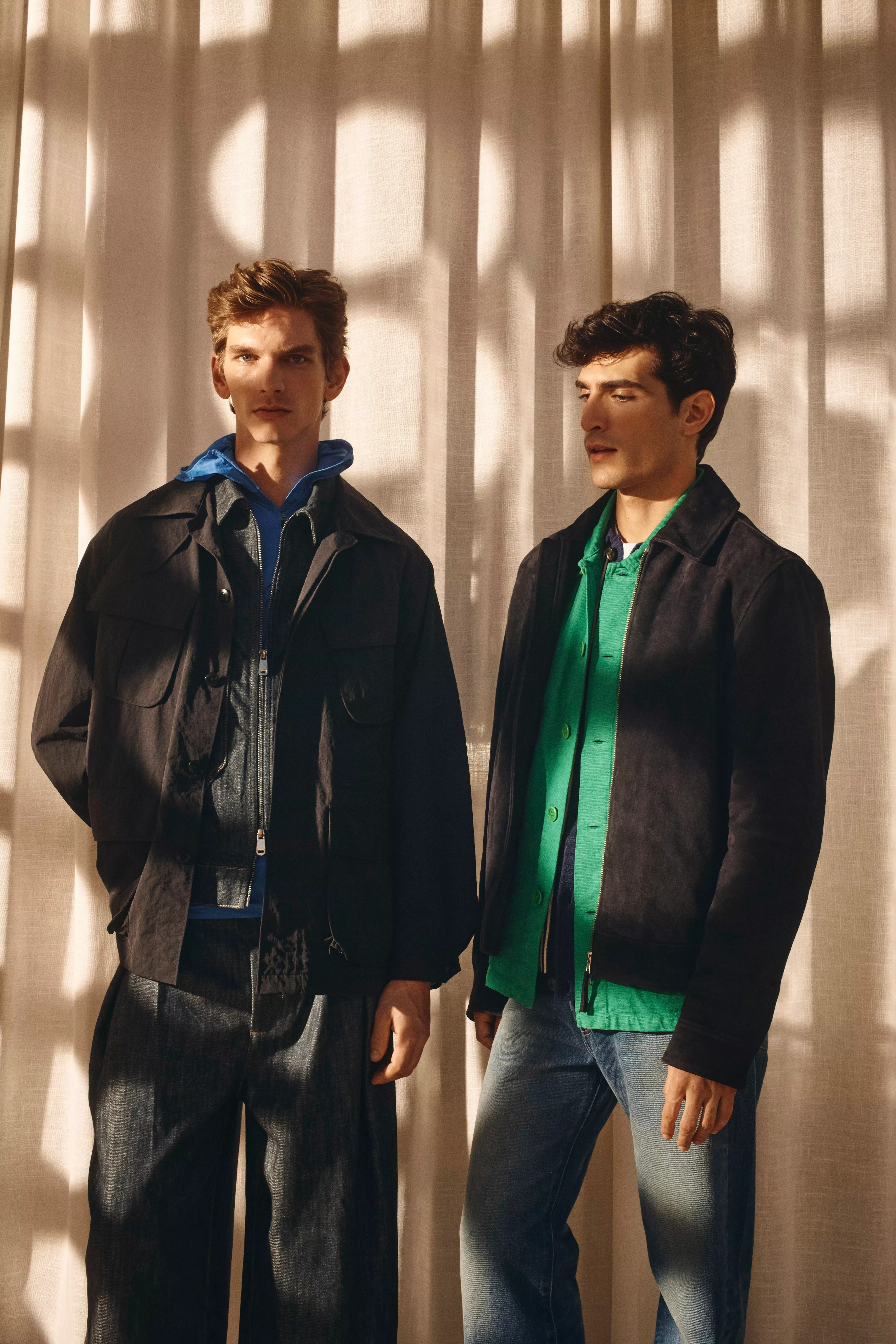 Two men dressed in casual black jackets and denim jeans 