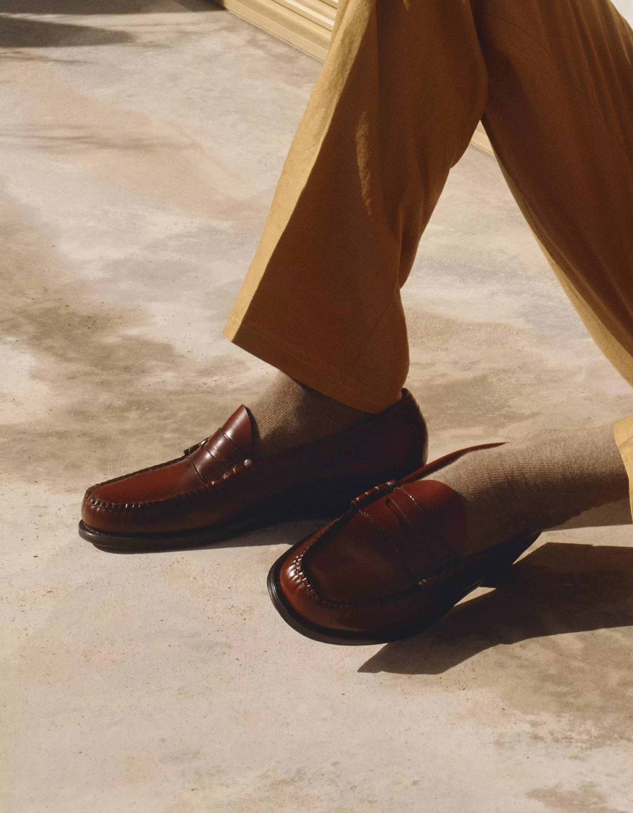 Man wearing leather brown loafers with beige socks 