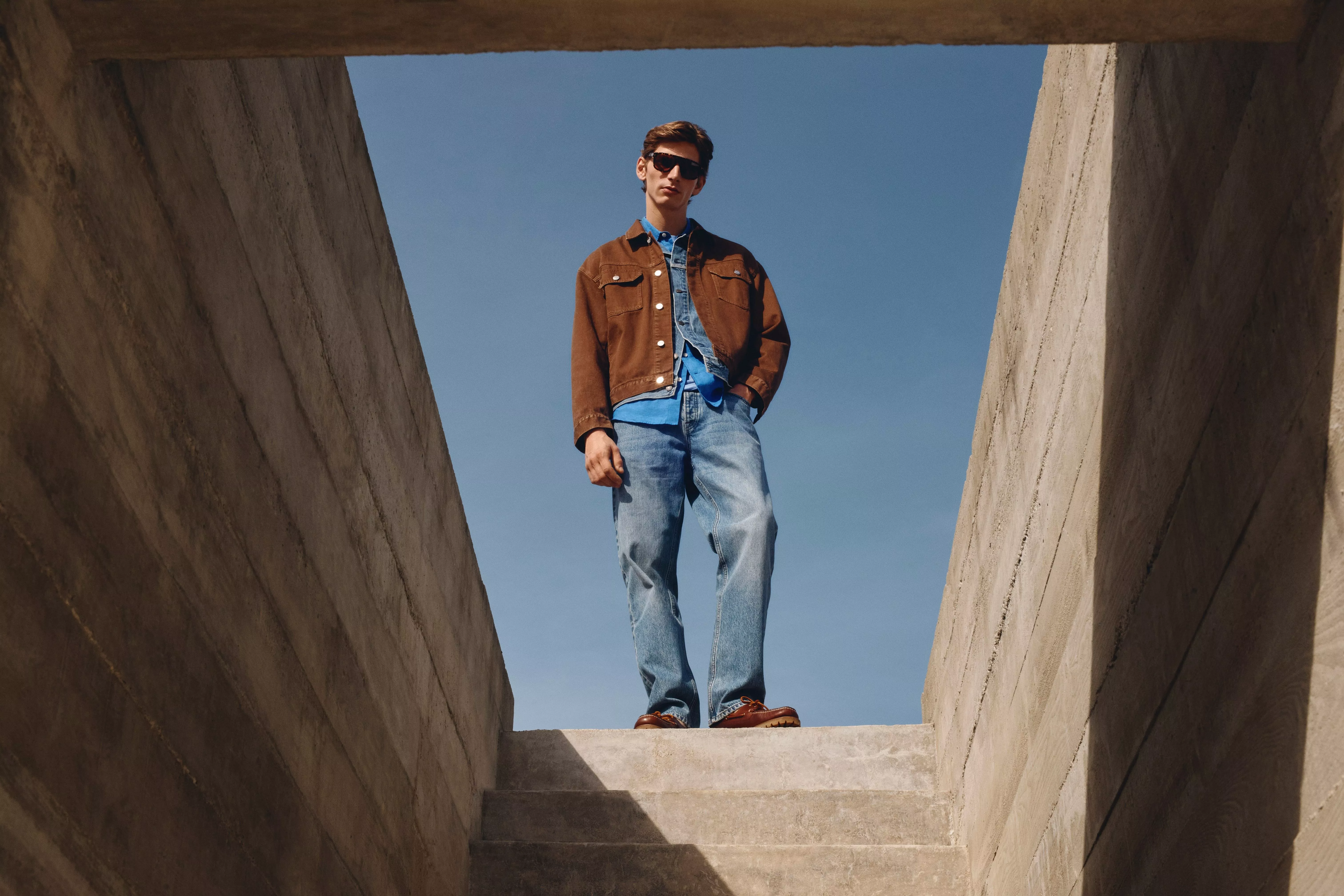 Man wearing brown denim jacket and blue jeans 