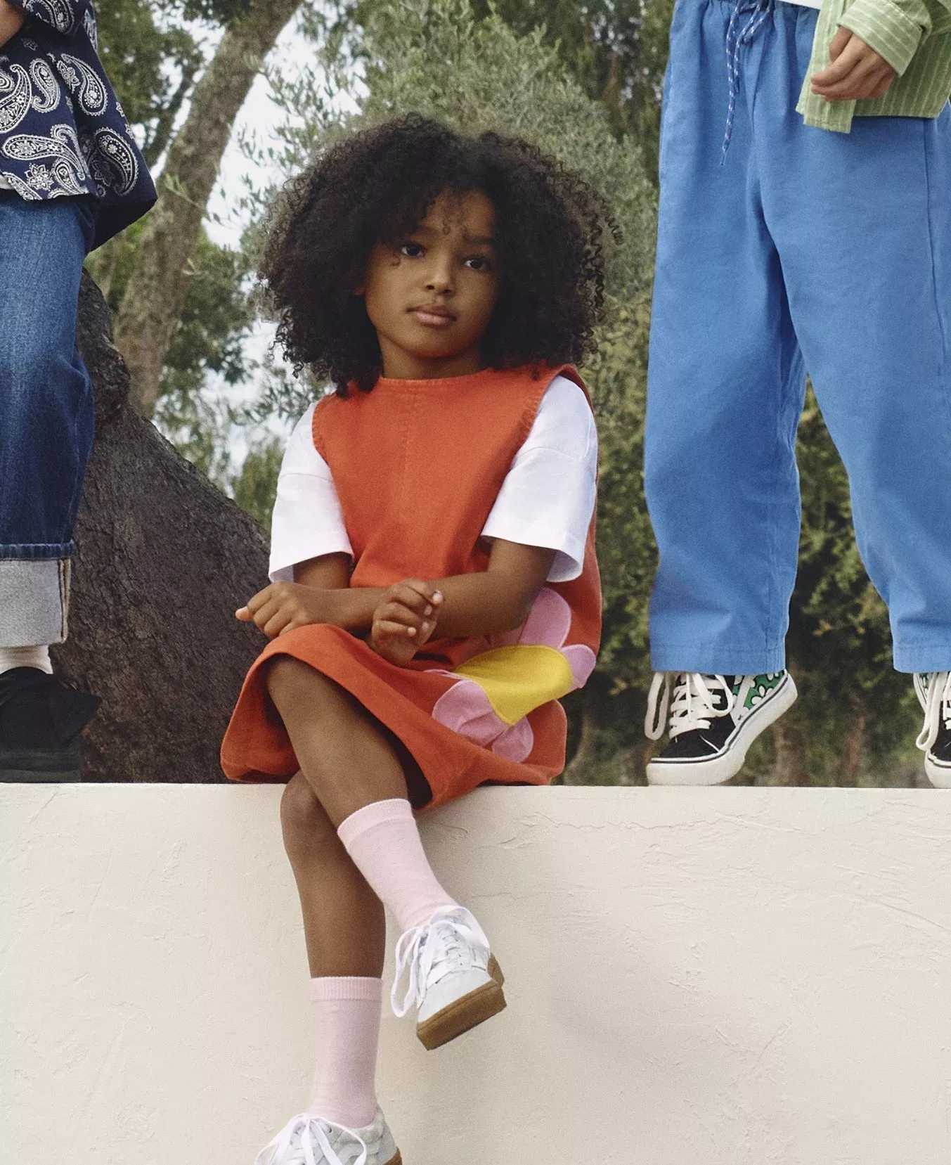 girl wearing red dress with white cap sleeves trainers and pink ankle socks