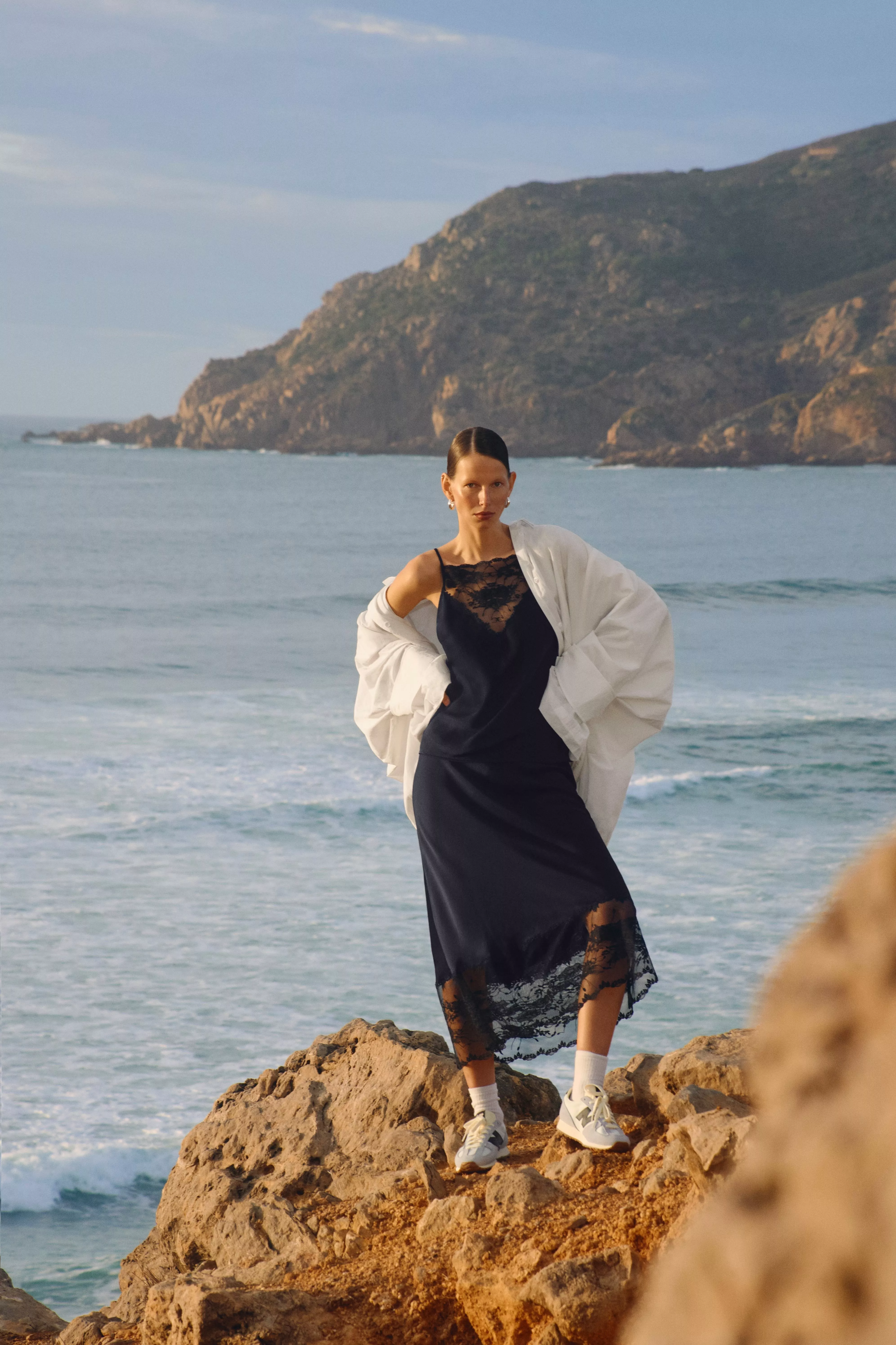 woman wearing a black lace trimmed midi dress