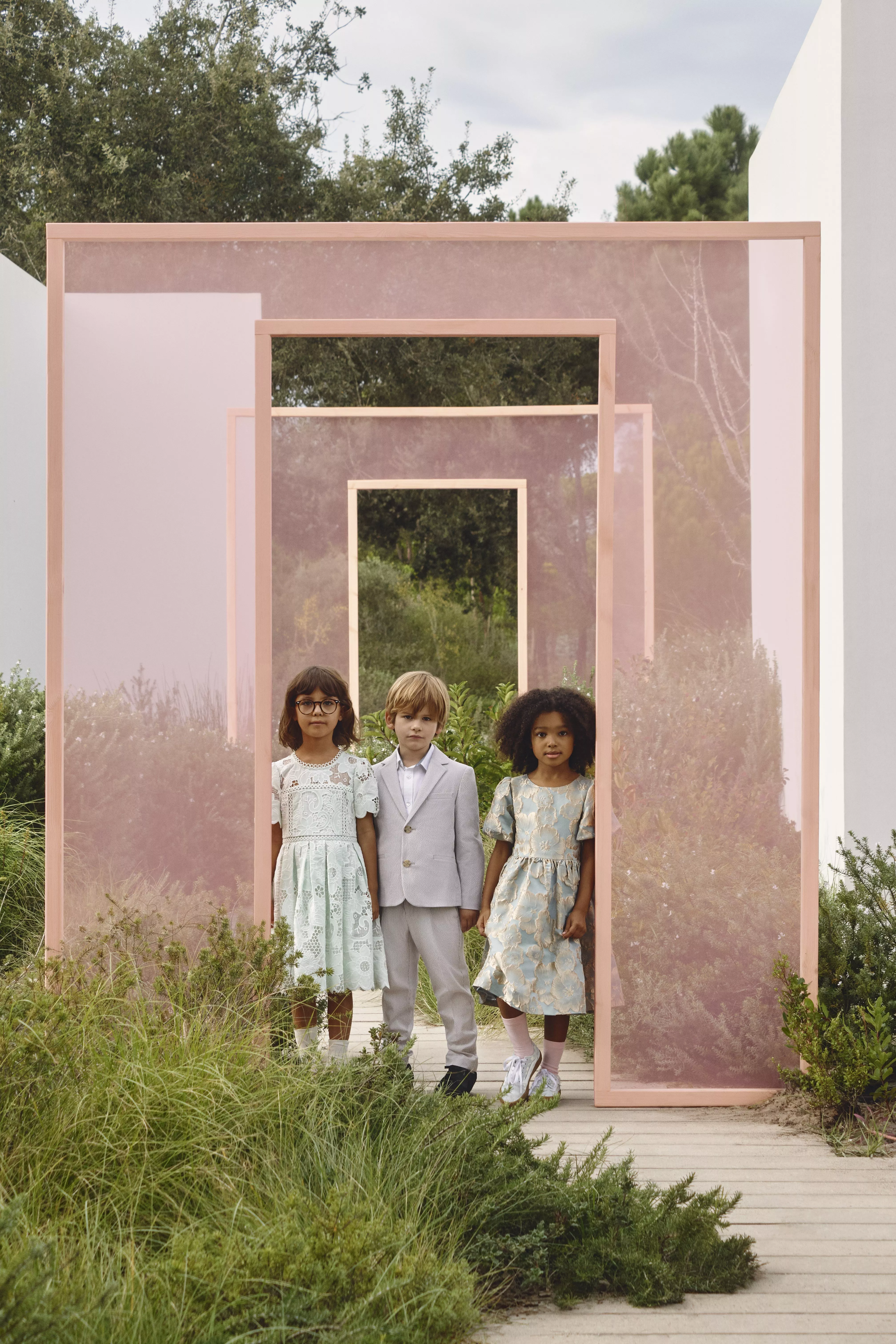 Two young girls and a boy wearing occasionwear