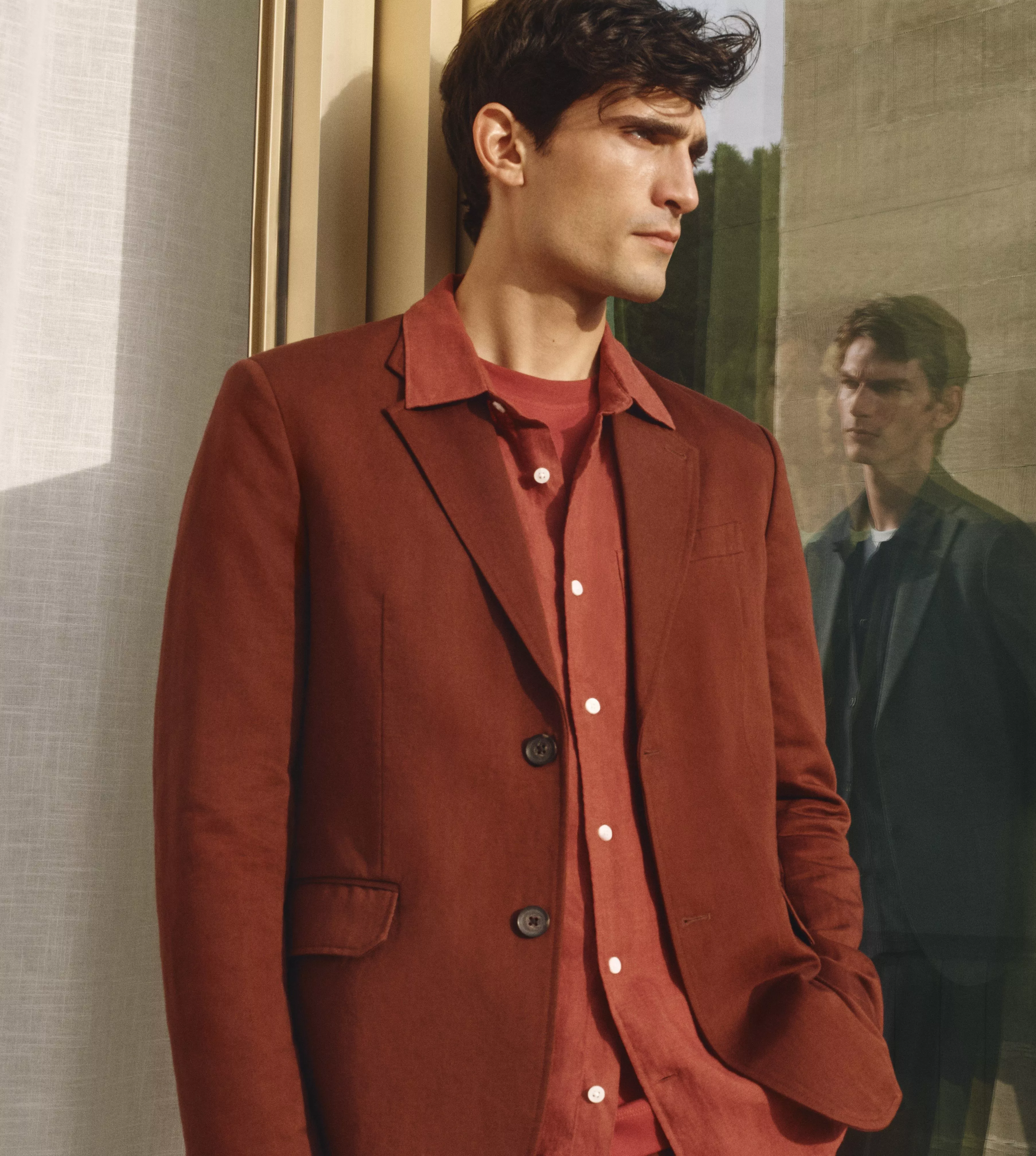 Man wearing a terracotta shirt with blazer on top 